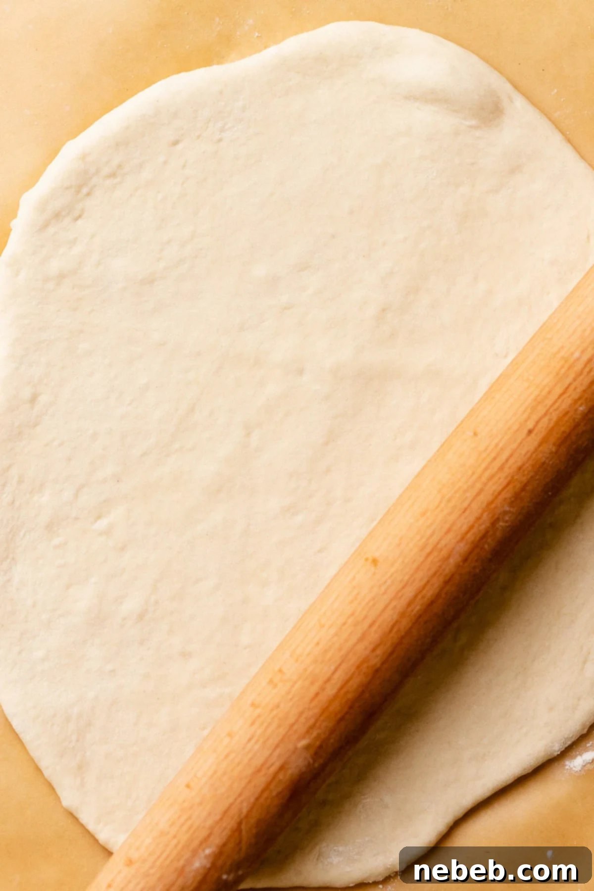Perfectly Soft and Chewy Homemade Pizza Dough 8 A rolling pin rolling out the pizza crust on a floured surface.
