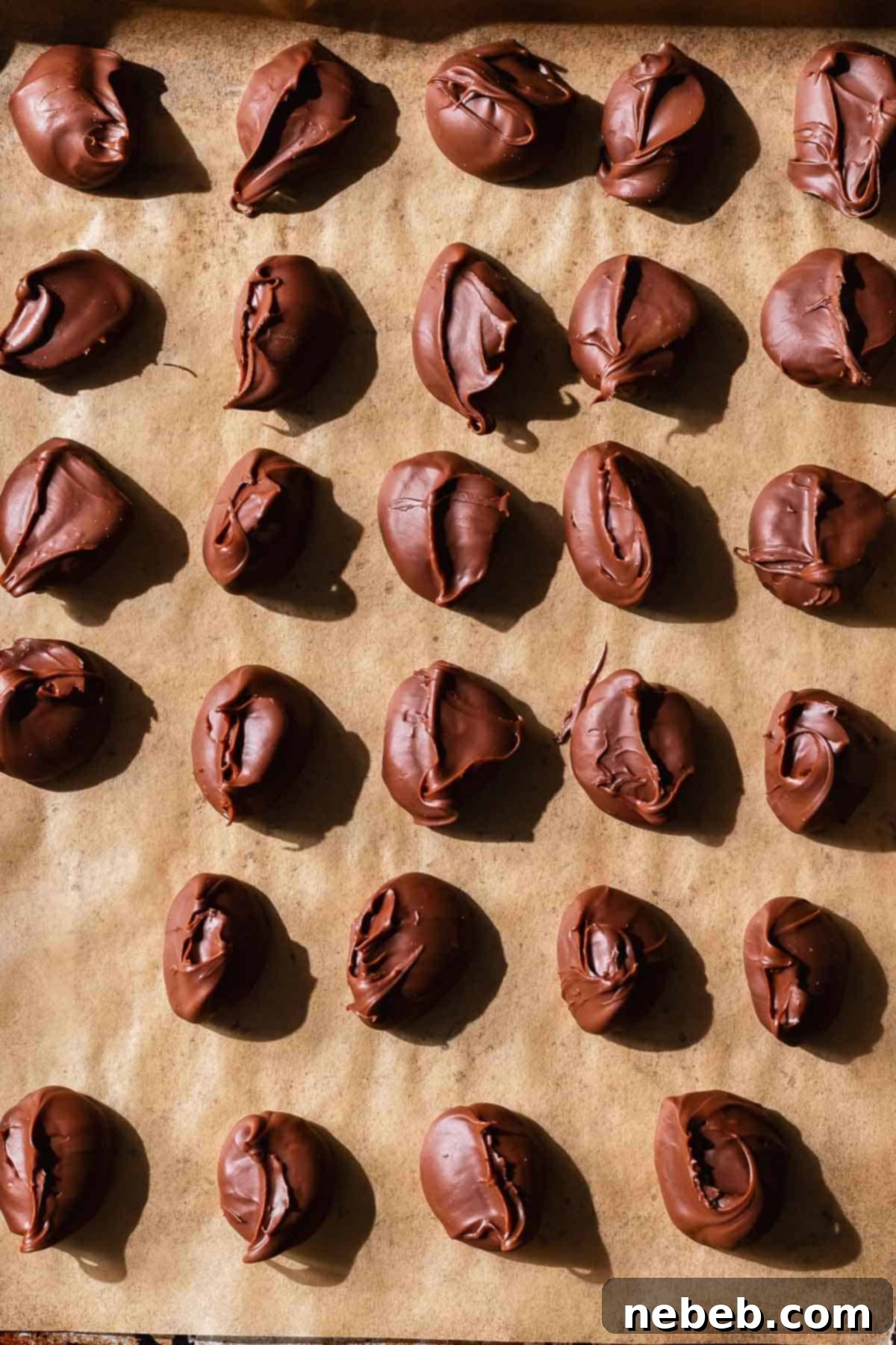 A baking tray filled with perfectly scooped portions of chocolate hazelnut spread, frozen solid and ready to be encased in cookie dough.