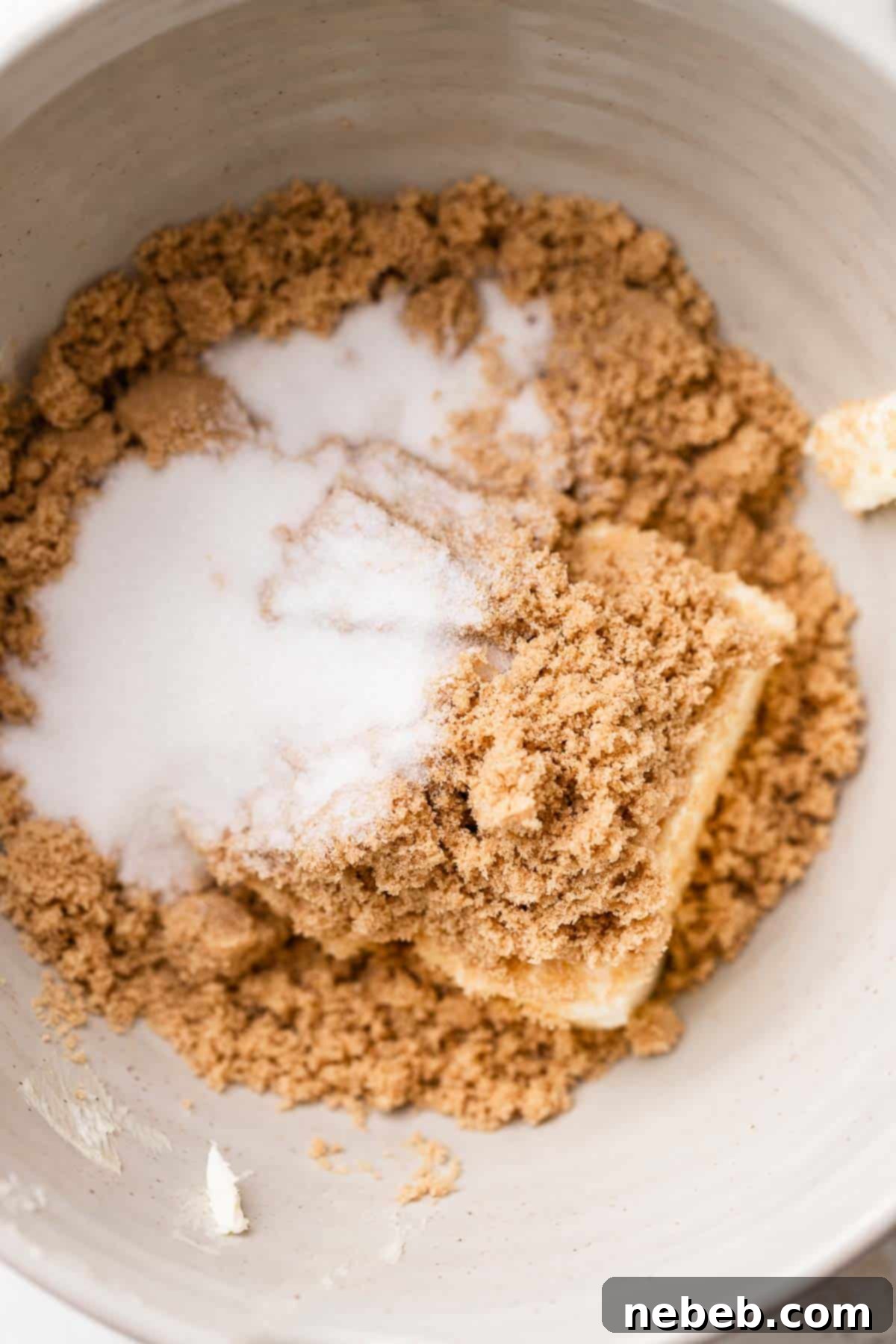 A mixing bowl with butter and sugar creaming together to make peppermint chocolate chip cookie dough.