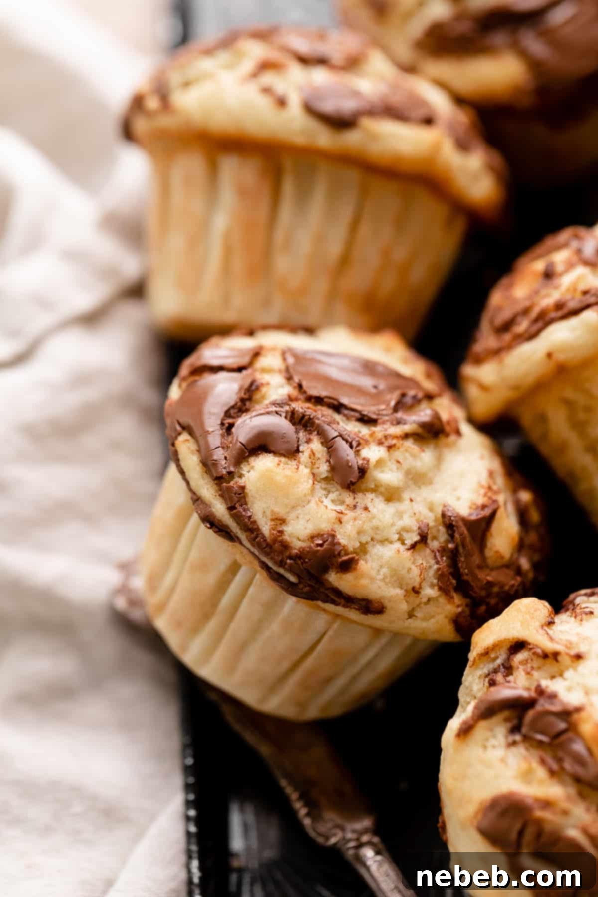 Nutella Swirl Banana Muffins 2 nutella banana muffin with swirled nutella on top.