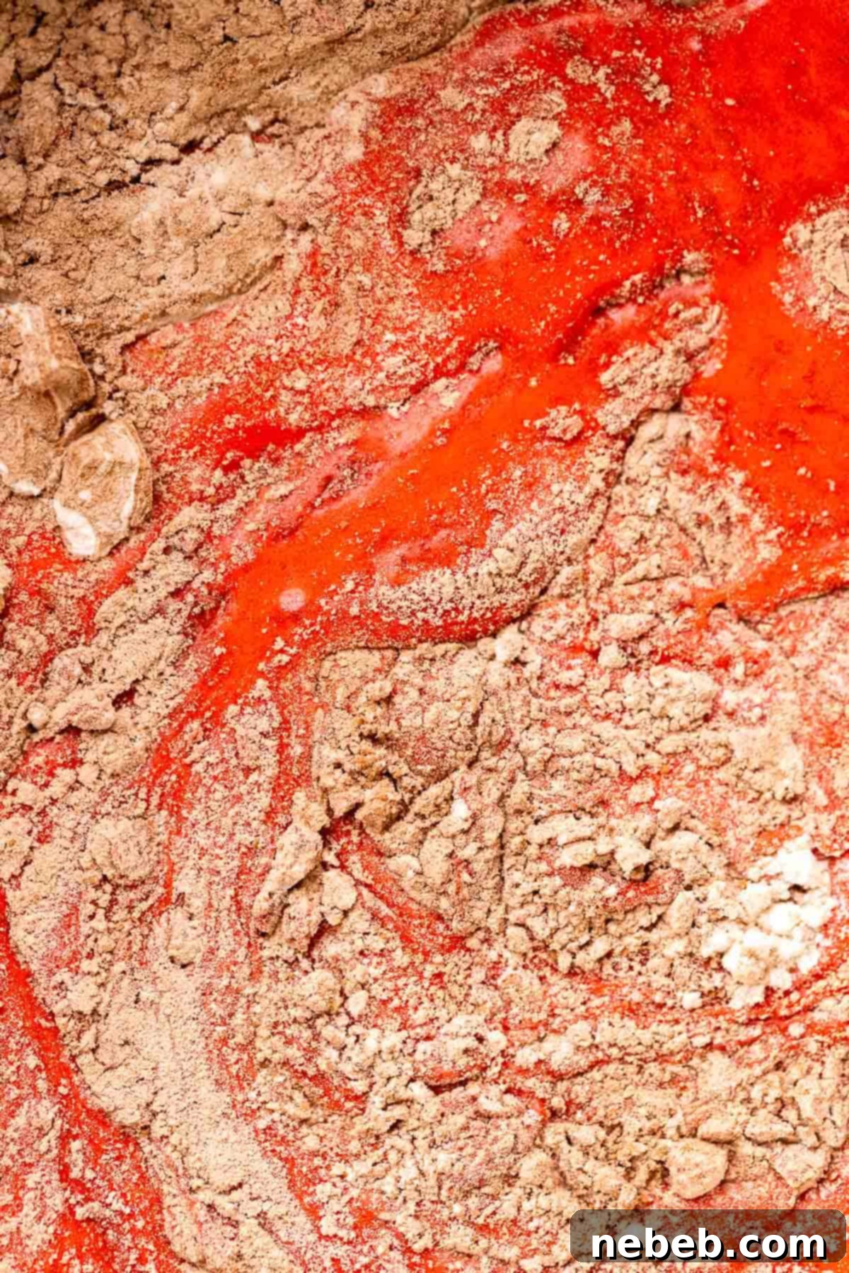 Dry ingredients being folded into the red velvet brownie batter.