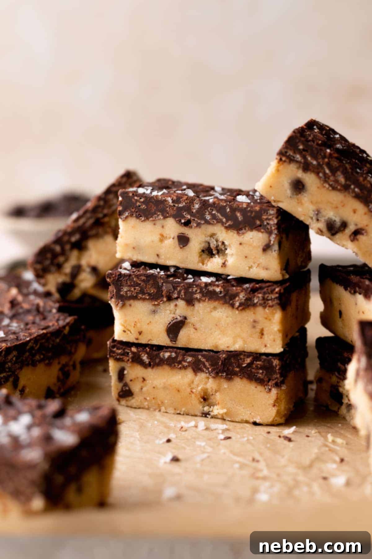 Golden Crunch Cookie Dough Bars 2 three cookie dough bars stacked on top of each other, showcasing the chocolate Krispie topping and cookie dough layers.