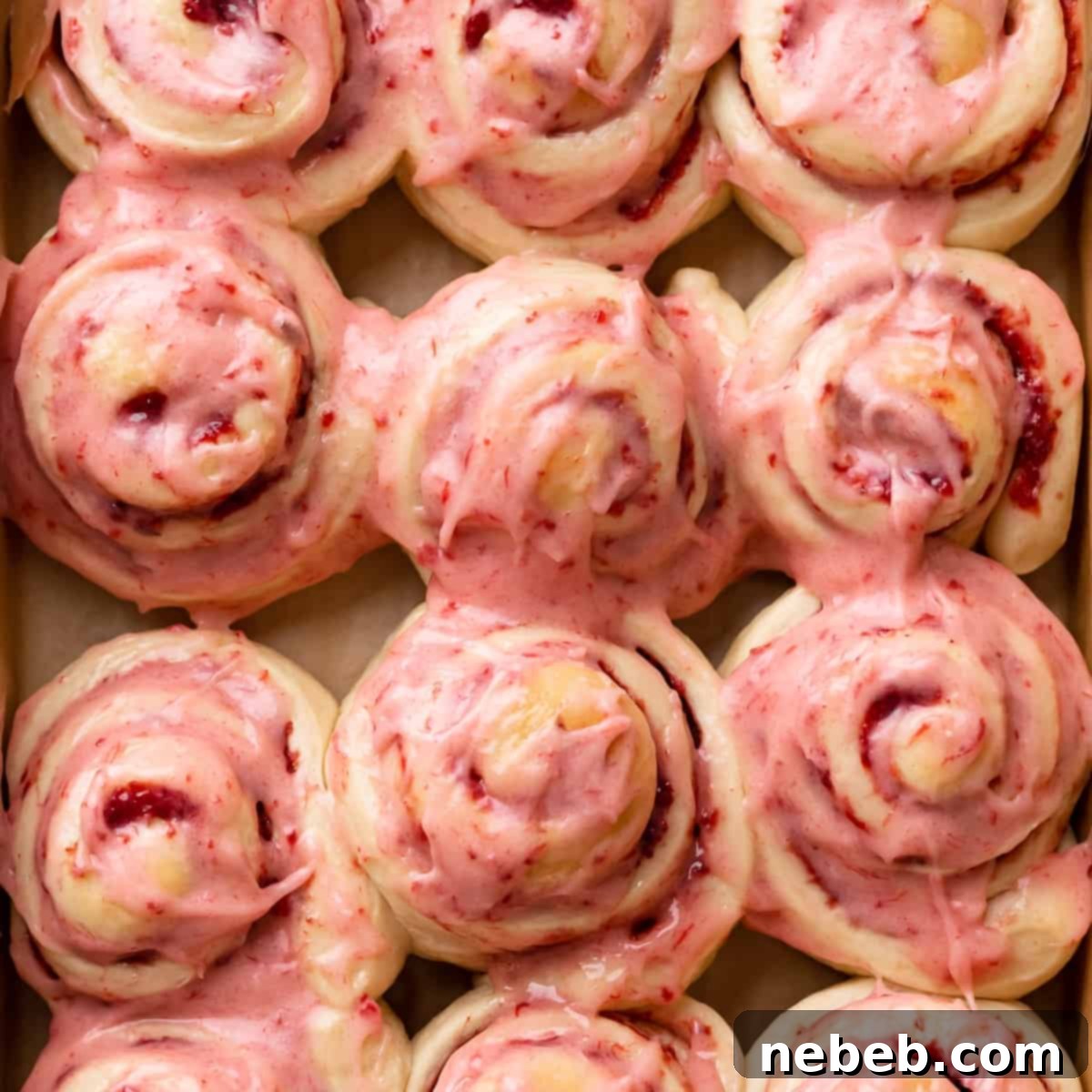 strawberry cinnamon rolls covered in strawberry cream cheese icing.