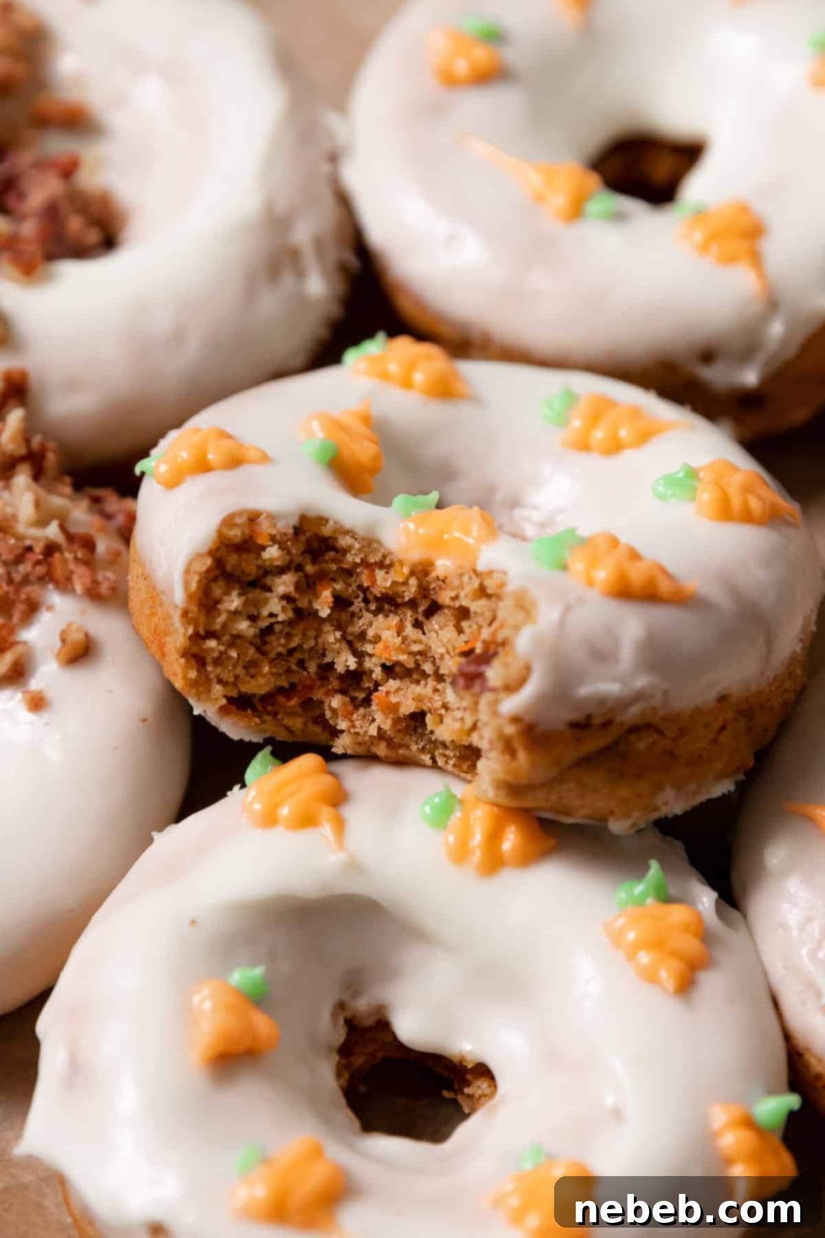 A baked carrot cake donut with a bite taken out of it, revealing its moist and spiced interior.