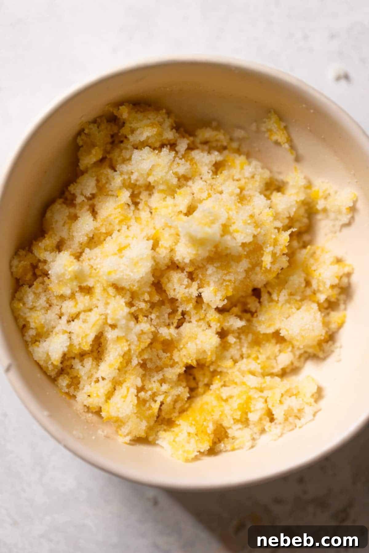 fresh lemon zest and sugar rubbed together in a mixing bowl.
