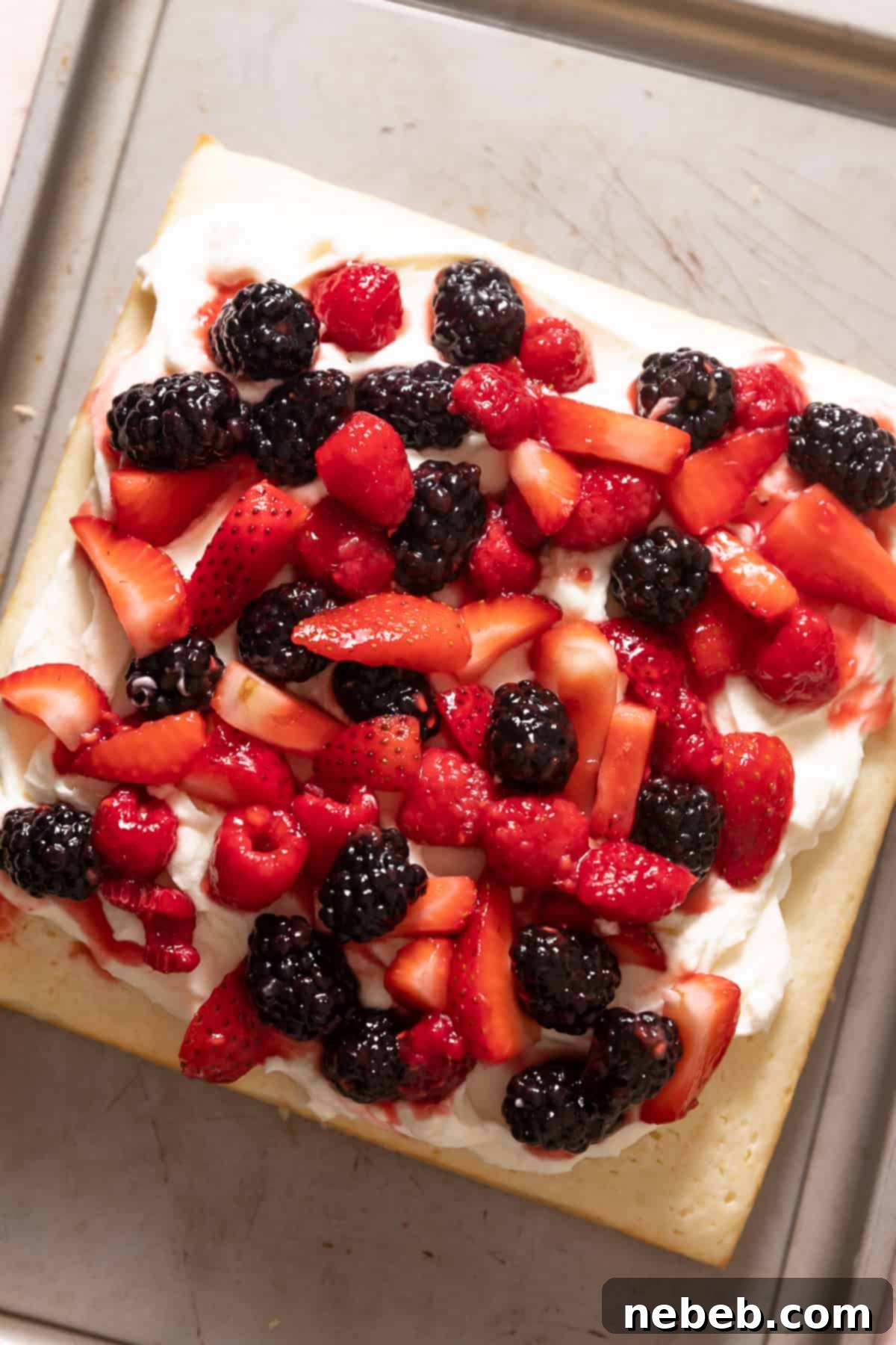 lemon cake with mascarpone frosting and fresh berries on top.