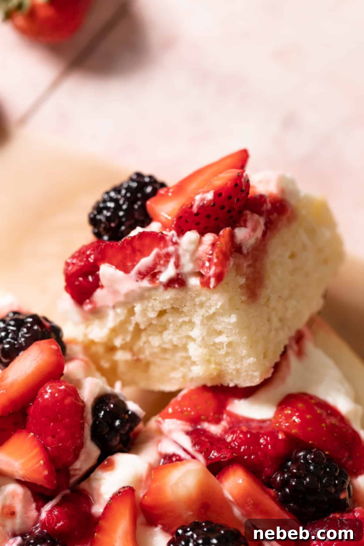 a slice of lemon berry mascarpone cake with fresh berries on top.