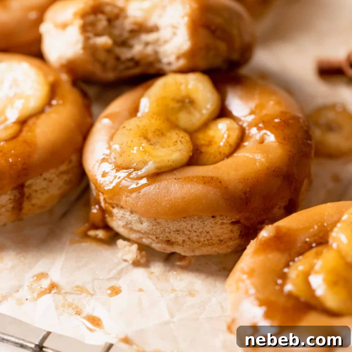 Baked banana donuts with brown sugar glaze and bananas on top, styled beautifully.
