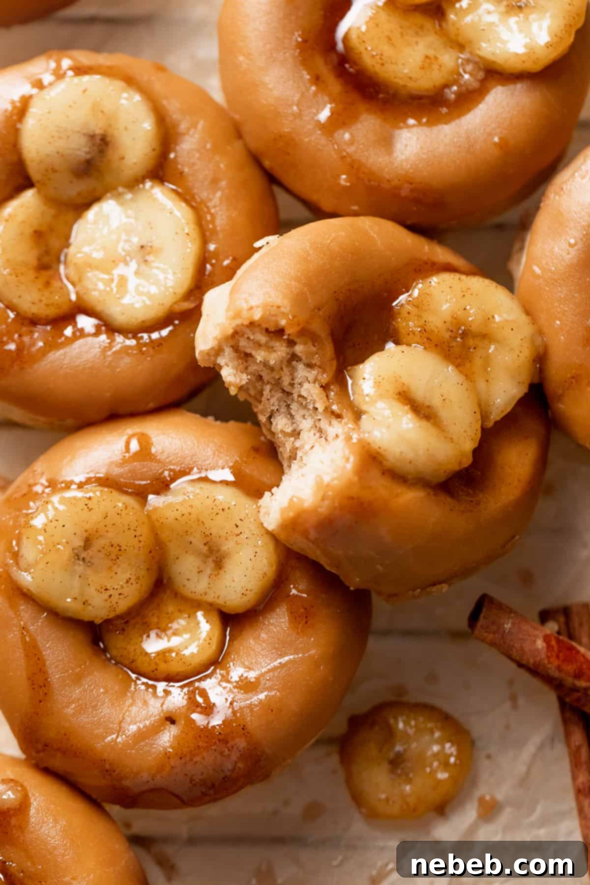 Homemade banana donuts with caramelized bananas on top, elegantly arranged on a serving plate.