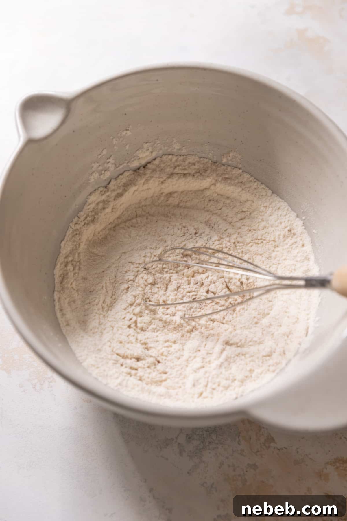 Whisking together the dry ingredients in a large mixing bowl for the banana donut batter.