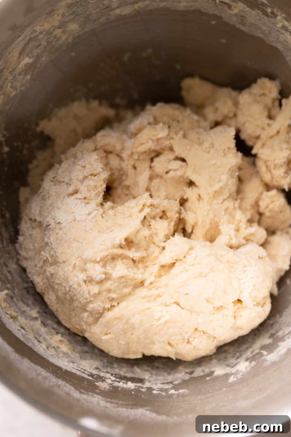 Shaggy, rough dough ball in a stand mixer bowl after initial mixing.