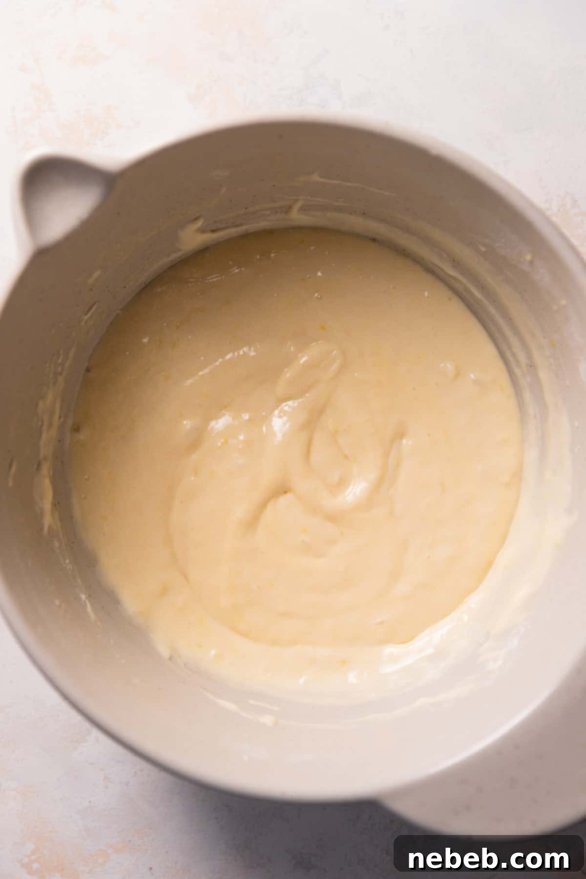 The lemon cake batter in a mixing bowl is now smooth and fully combined, ready for baking.