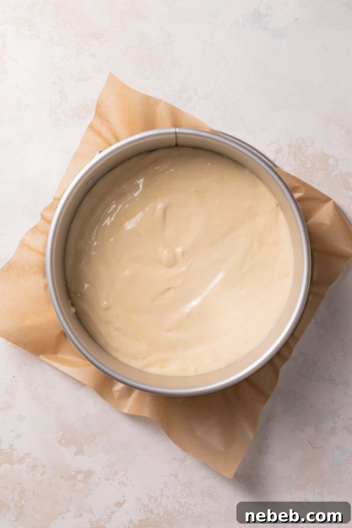 A springform cake pan filled with vanilla cake batter, ready for the oven.