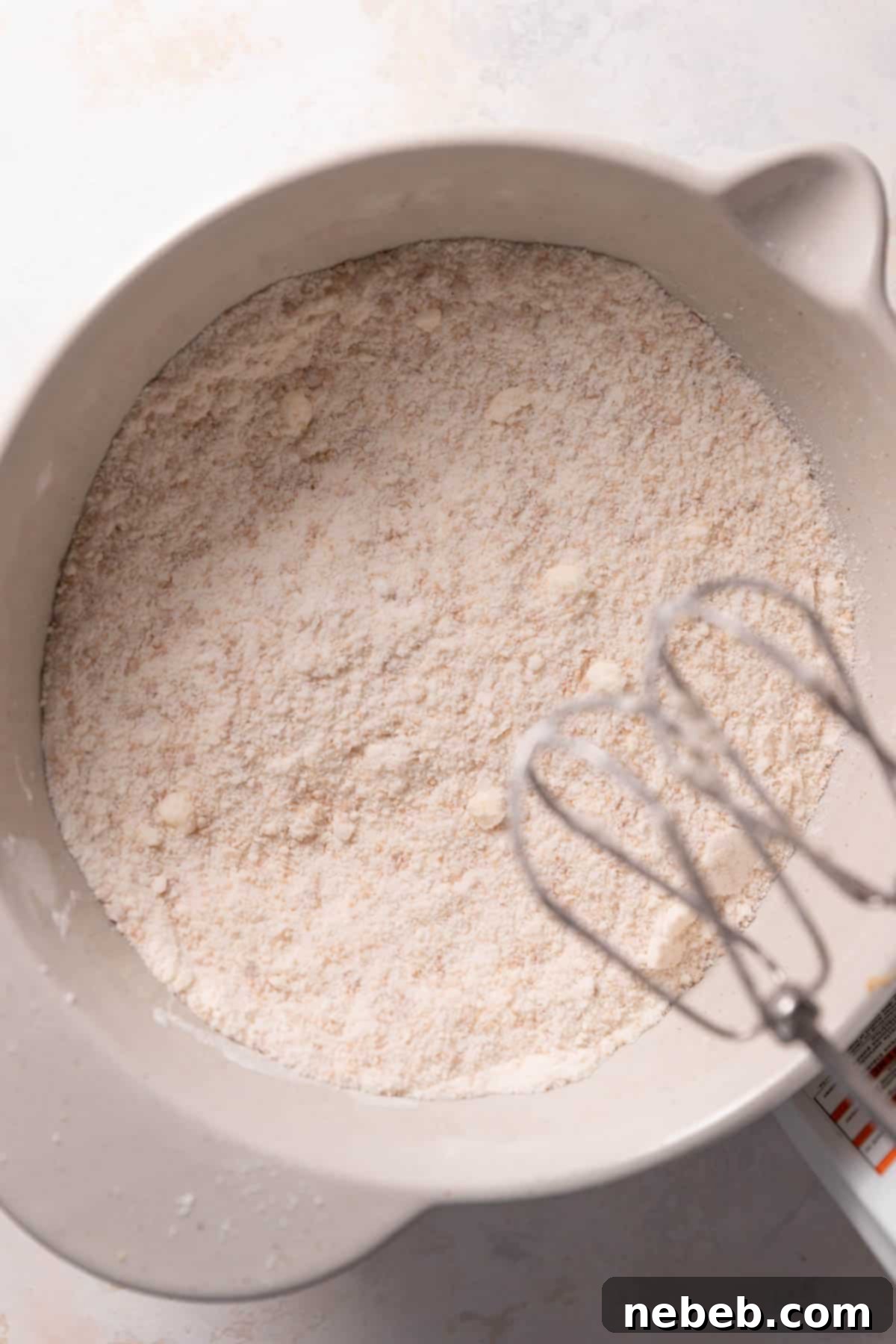 cookie butter, butter, and dry ingredients mixed together in a bowl.