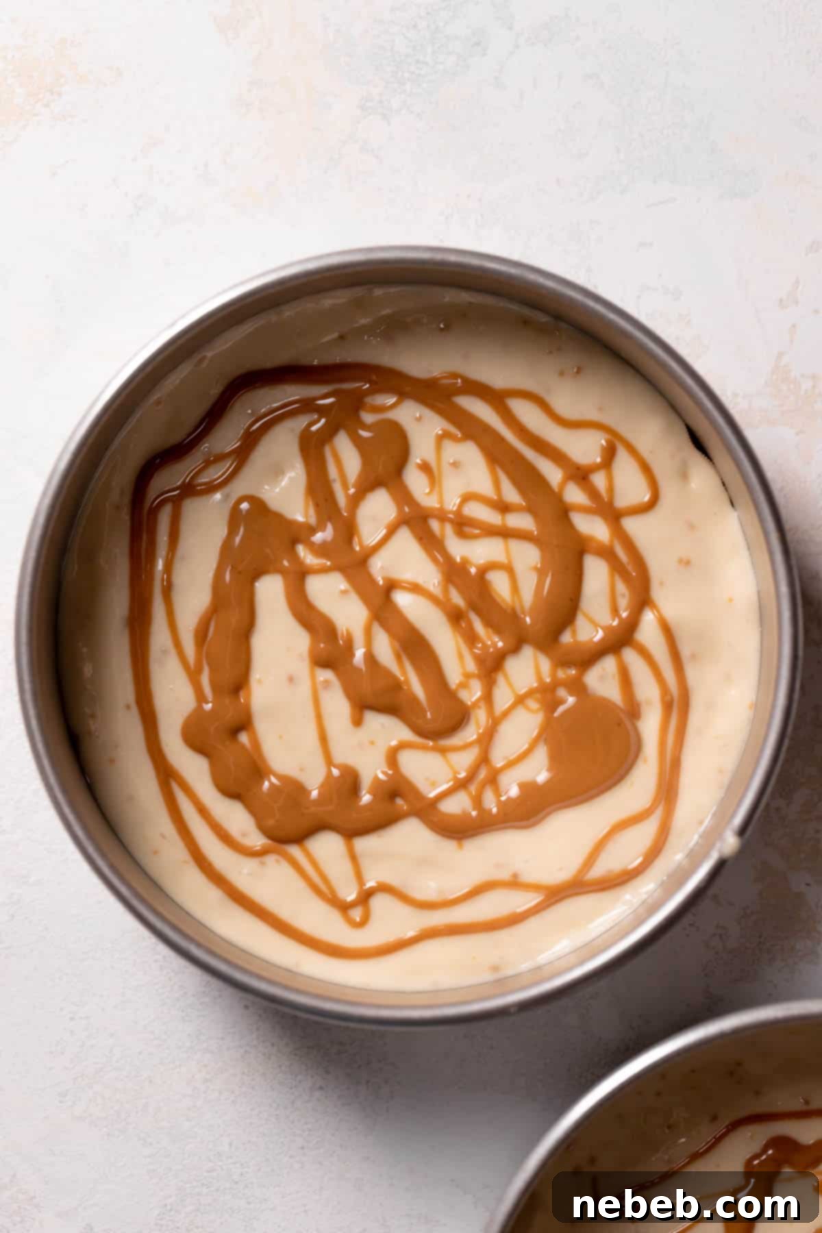 speculoos spread drizzled over the cake batter in a cake pan.