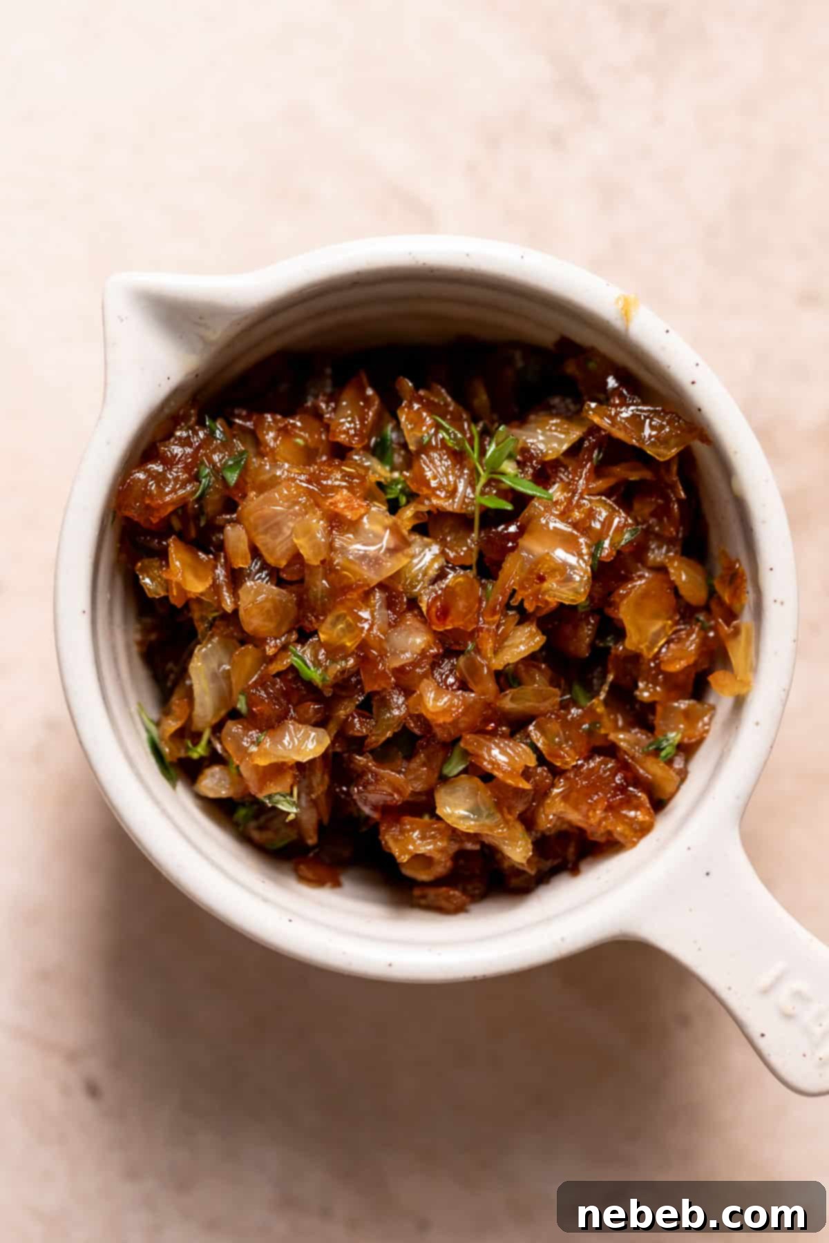 A bowl filled with rich, golden-brown caramelized onions, prepared for topping the focaccia.