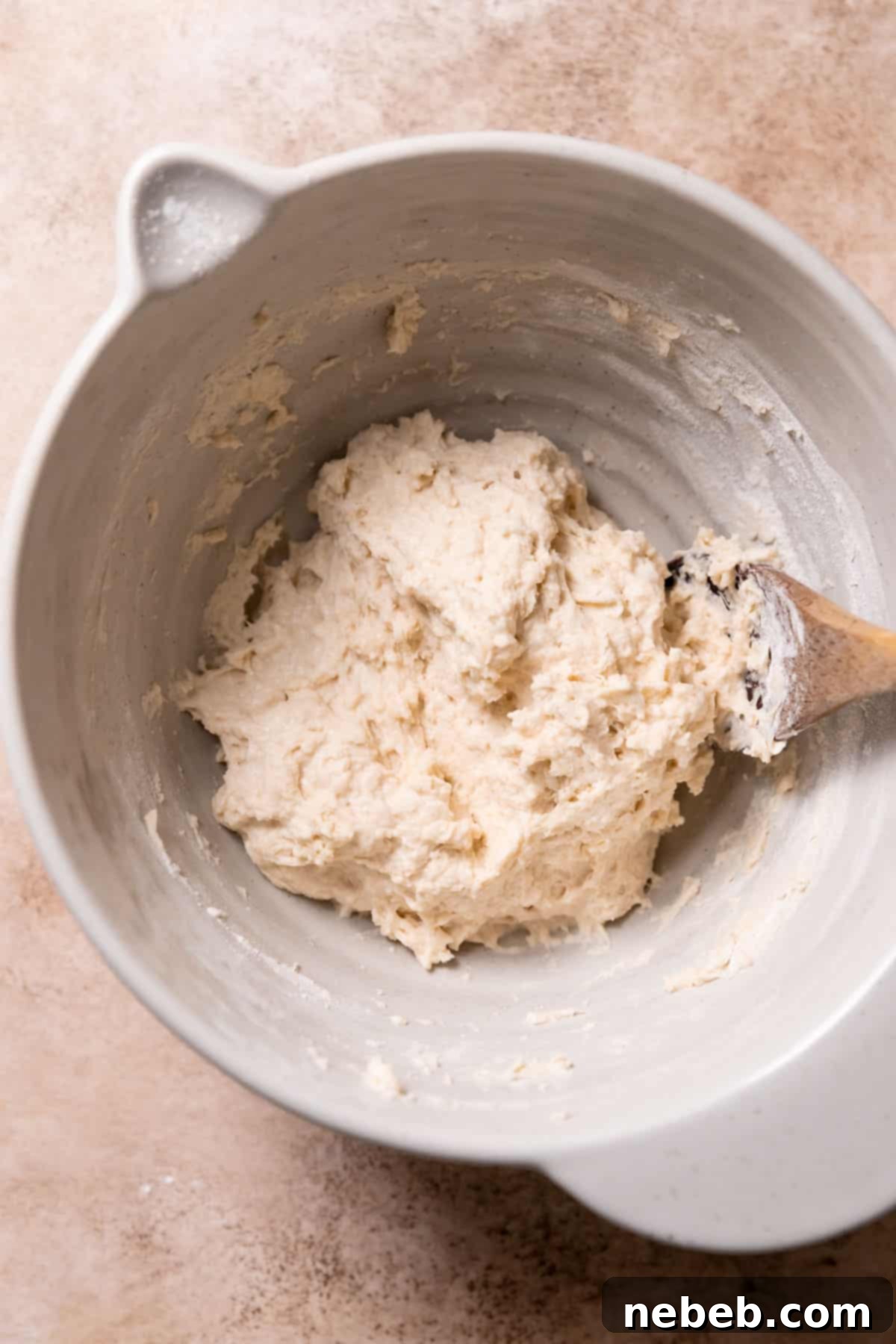 A large mixing bowl containing focaccia dough after all ingredients have been combined, showing a shaggy texture.
