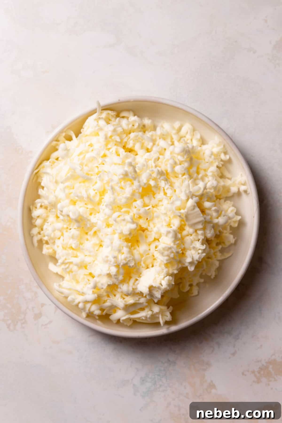 Shredded cold butter in a white bowl, ready for pie dough.