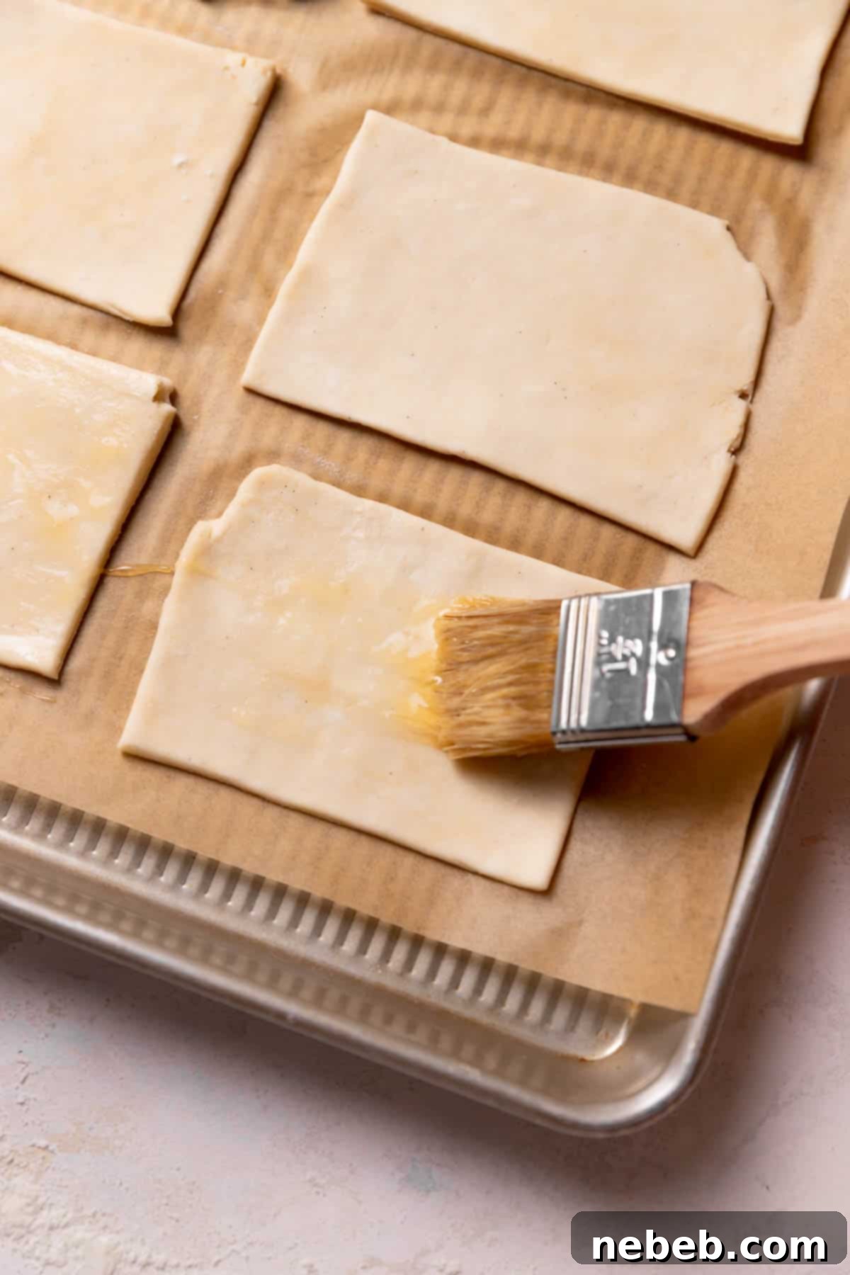 Brushing the pop tart squares with egg wash to create a seal.