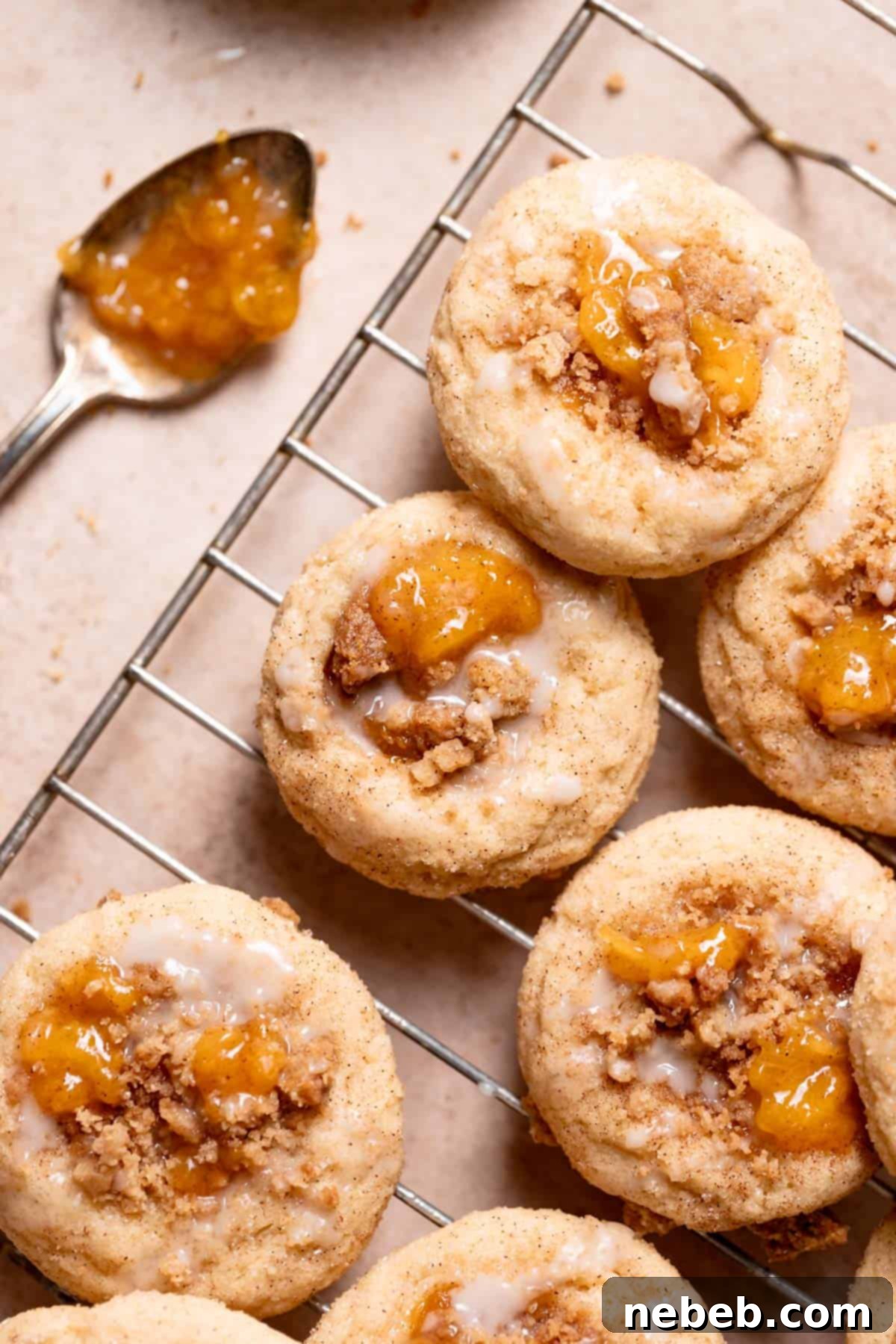 Delicious peach cobbler cookies topped with peach jam and vanilla glaze, ready to be enjoyed.