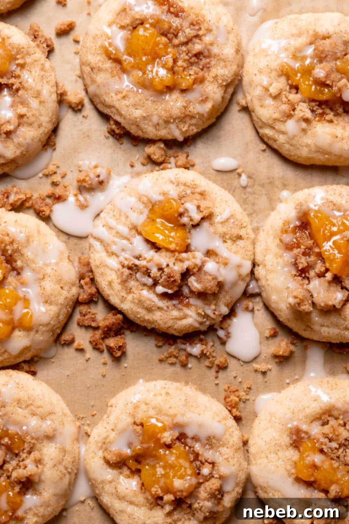 Baked peach pie cookies cooling on a wire rack, drizzled with vanilla glaze.