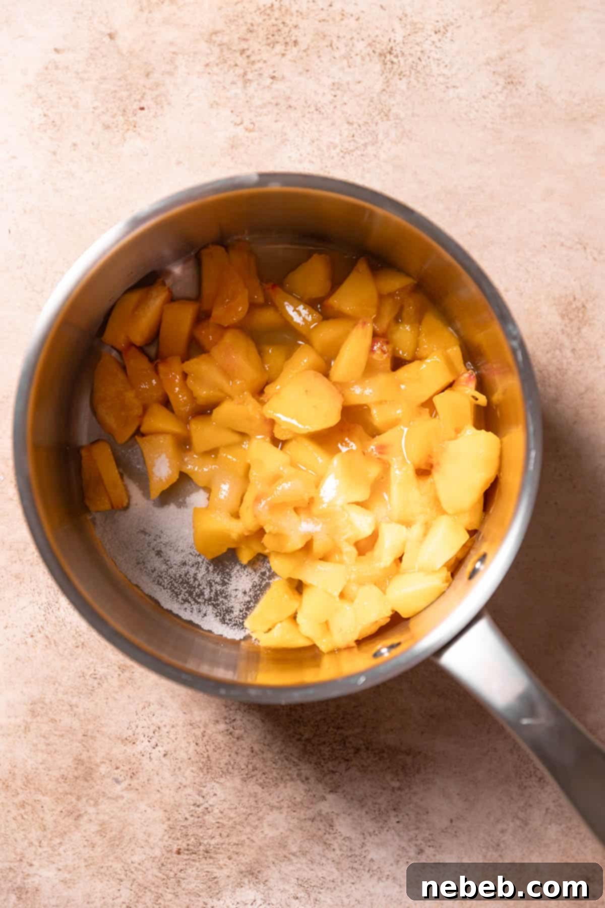 Fresh diced peaches cooking in a pot for the peach cobbler filling.