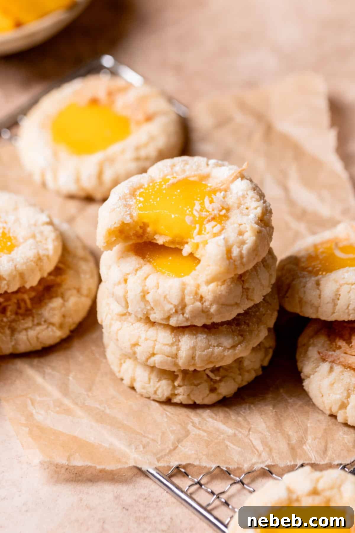 A beautiful stack of chewy mango cookies on brown parchment paper, highlighting their soft texture and crinkle effect.
