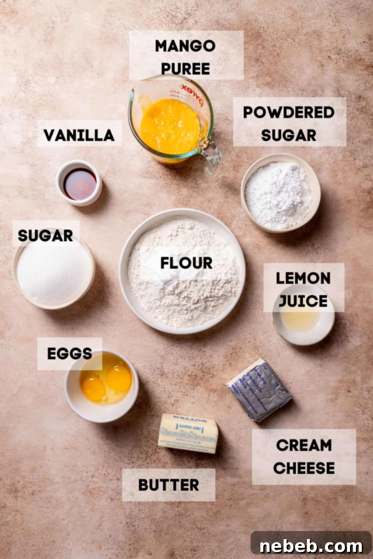 Bowls of ingredients for mango cookies laid out on a table, including mango puree, flour, sugar, and butter.