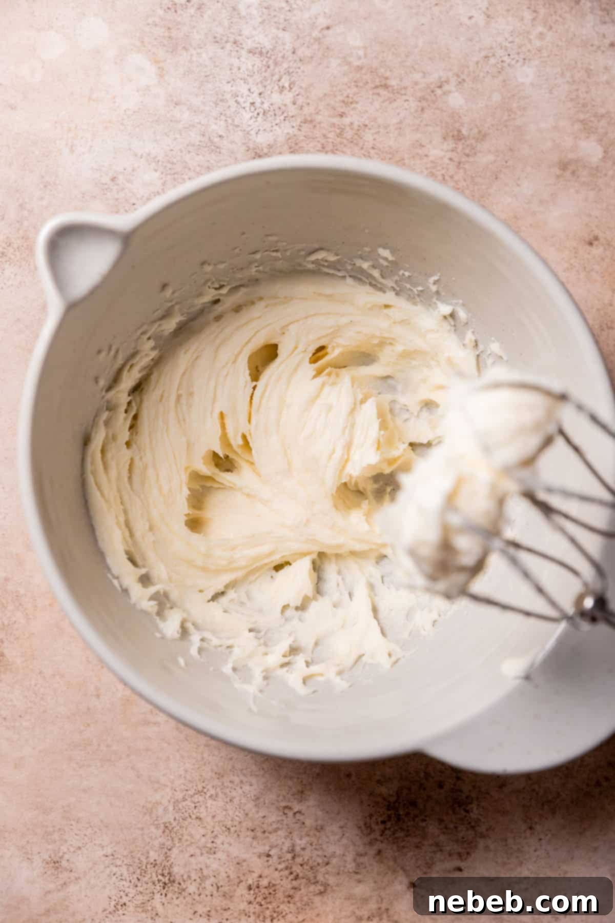 Creamed butter, sugar, and cream cheese in a mixing bowl, showcasing the fluffy texture.