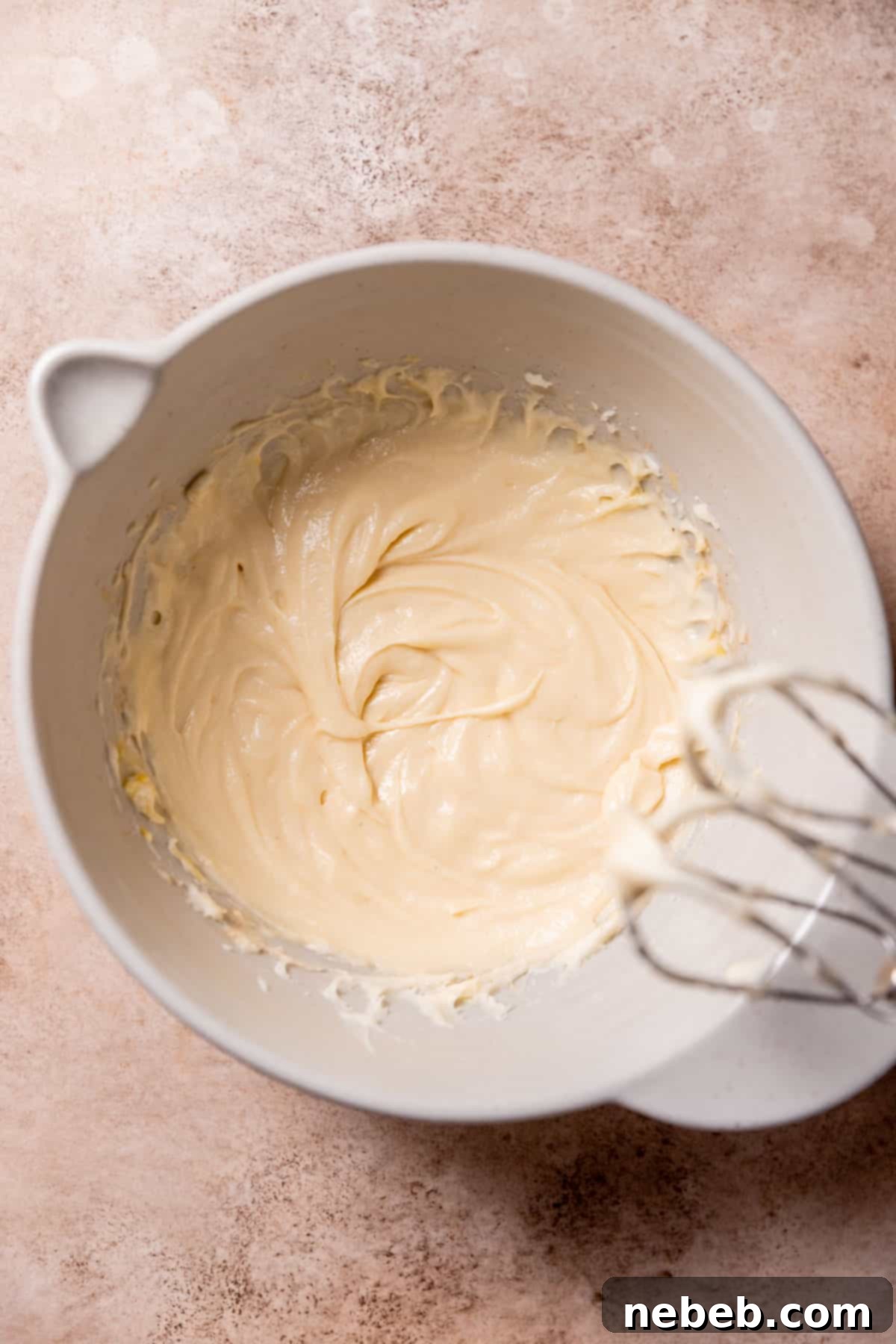 A smooth, yellow cookie batter in a mixing bowl after wet ingredients have been incorporated.