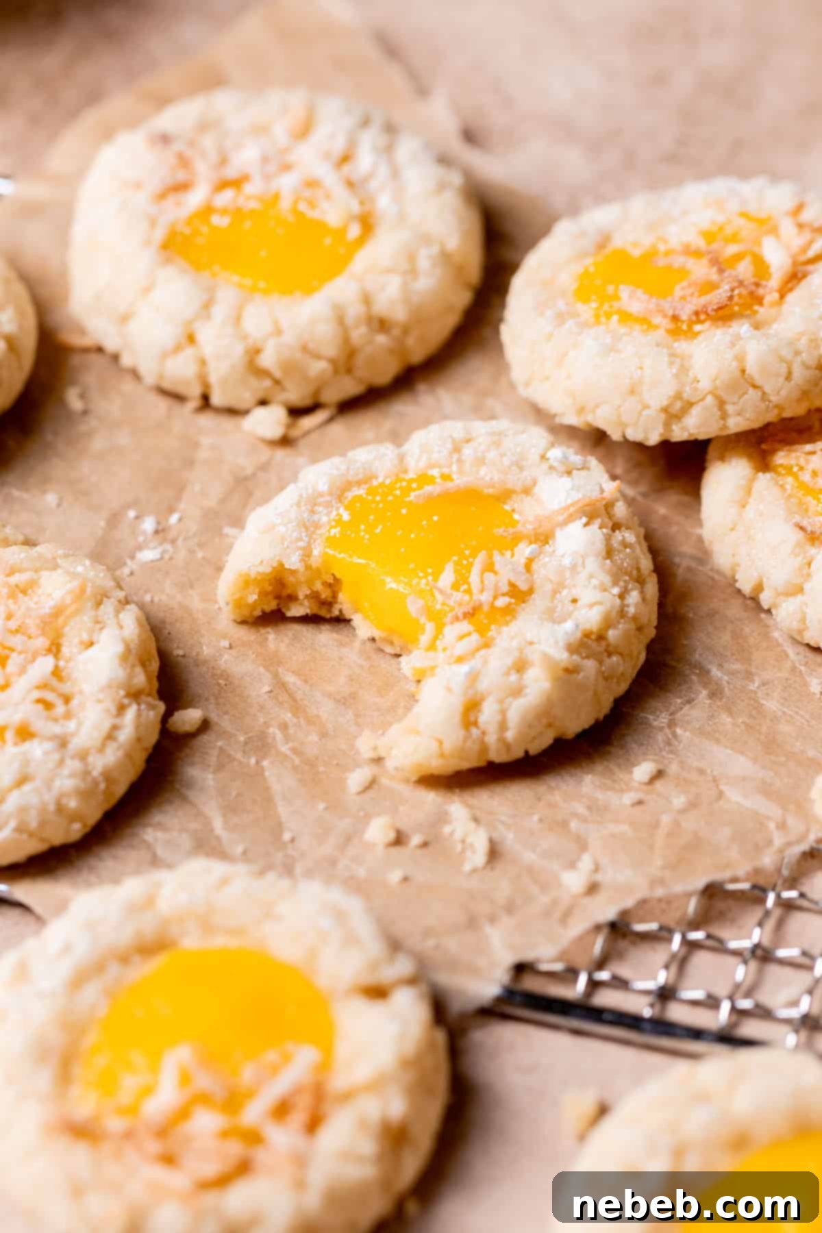 A delicious mango cookie with a bite taken out, revealing the soft interior and the juicy mango curd center.
