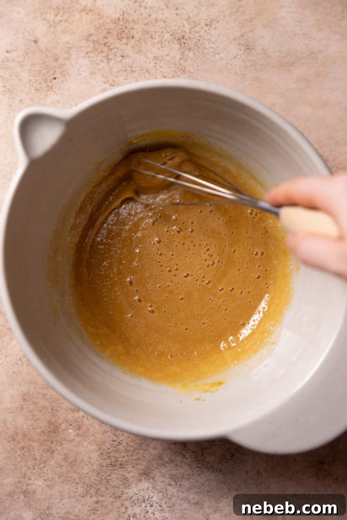 Whisking granulated and brown sugar with eggs and vanilla until thick and pale.