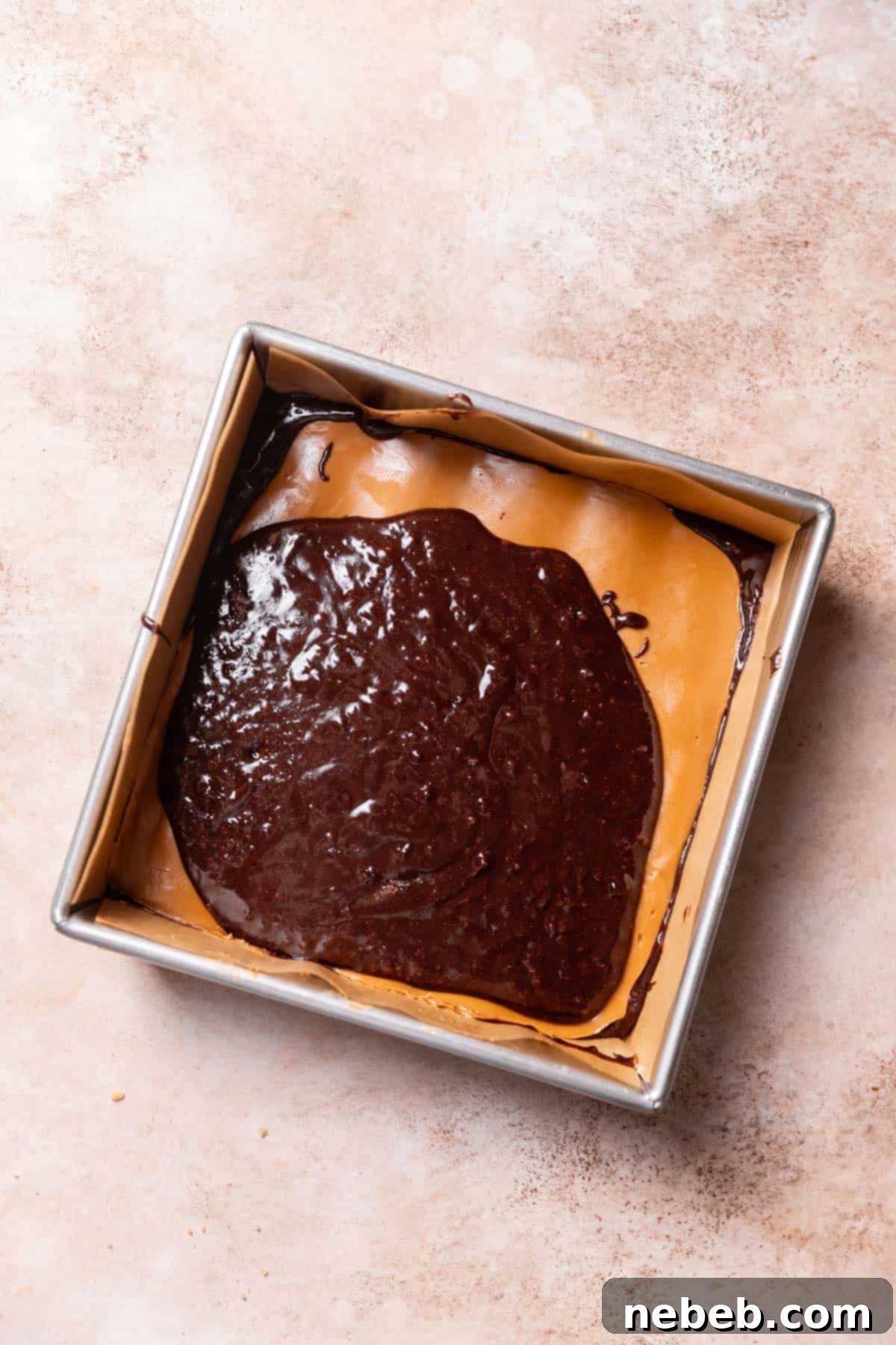 Half of the brownie batter spread, ready for the frozen cookie butter layer.