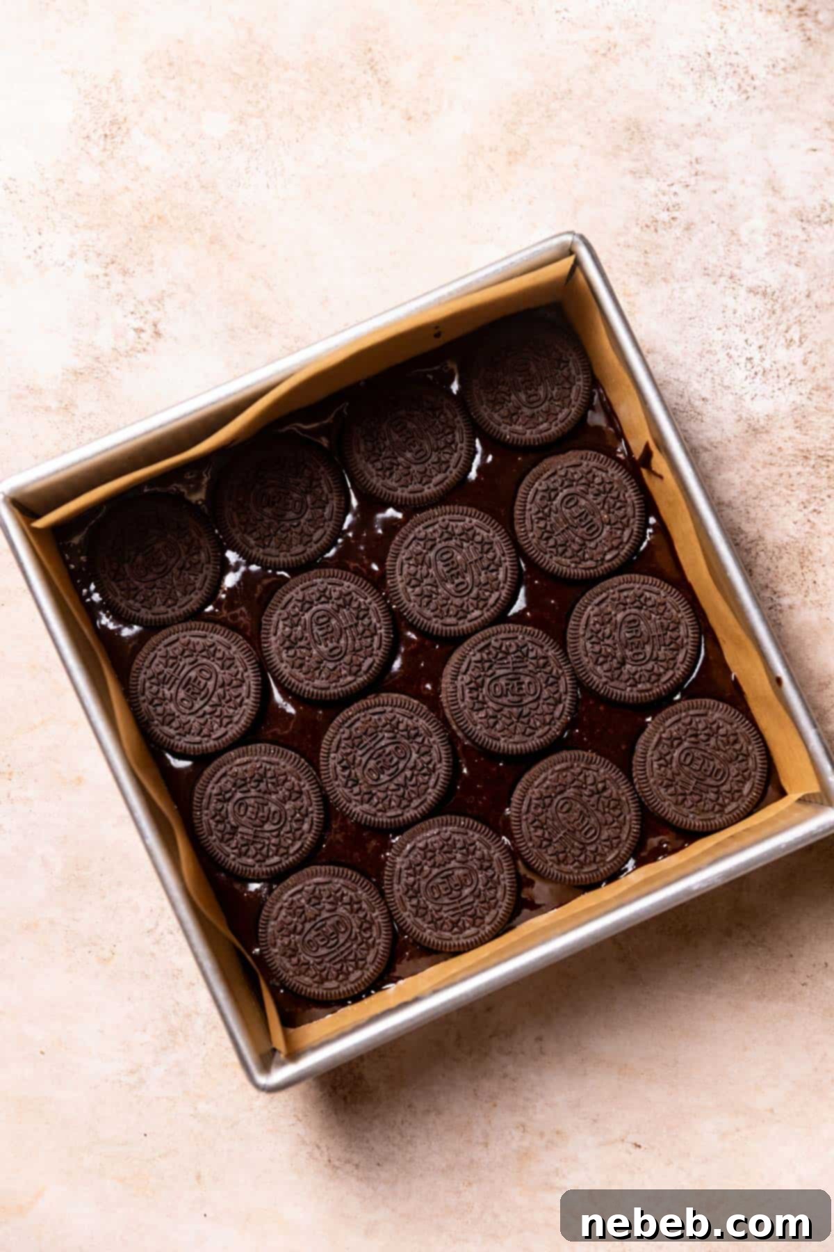 oreo cookies layered on top of the brownie batter in the baking pan.