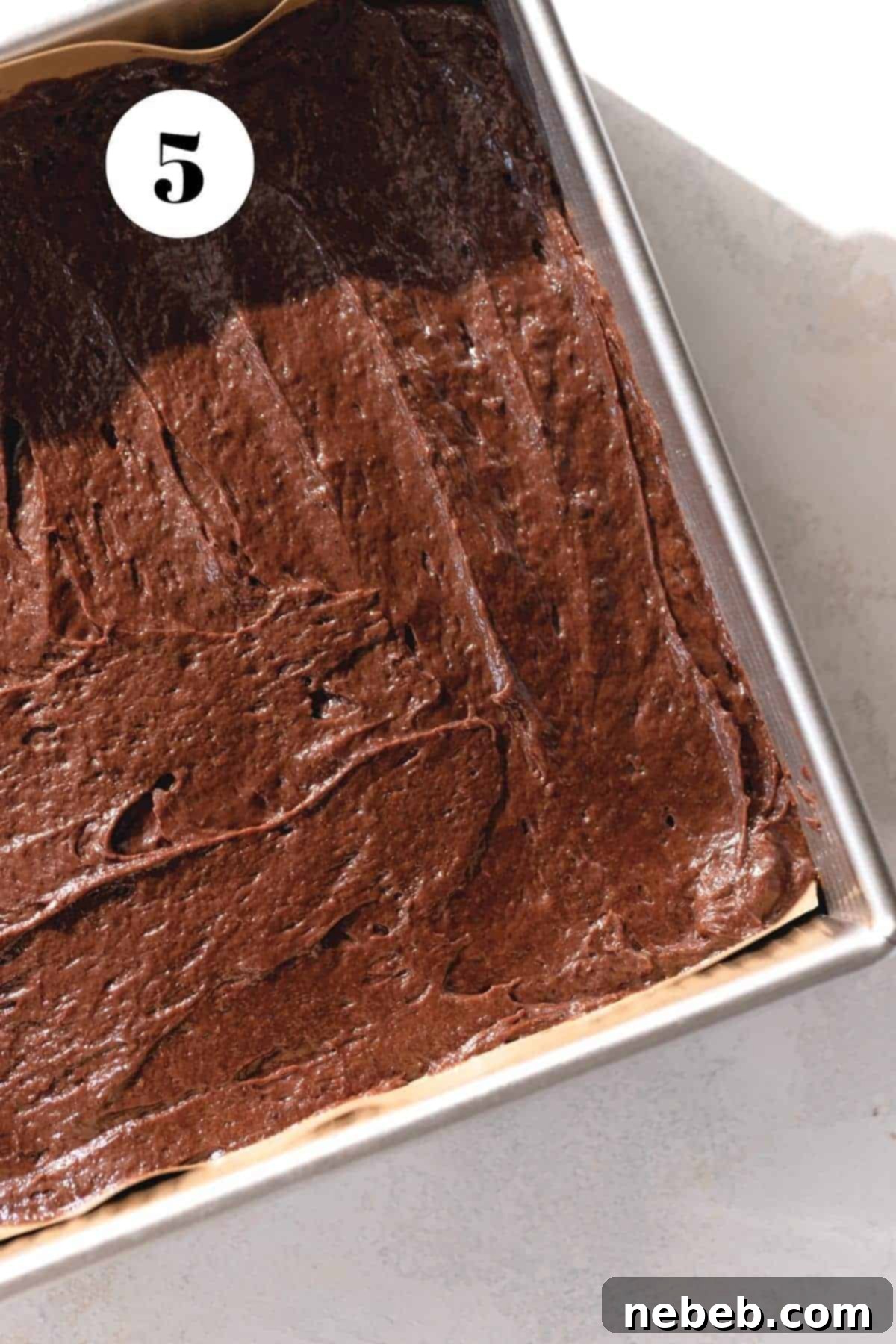 A process shot of the brownie batter smoothed evenly in a baking pan before baking.