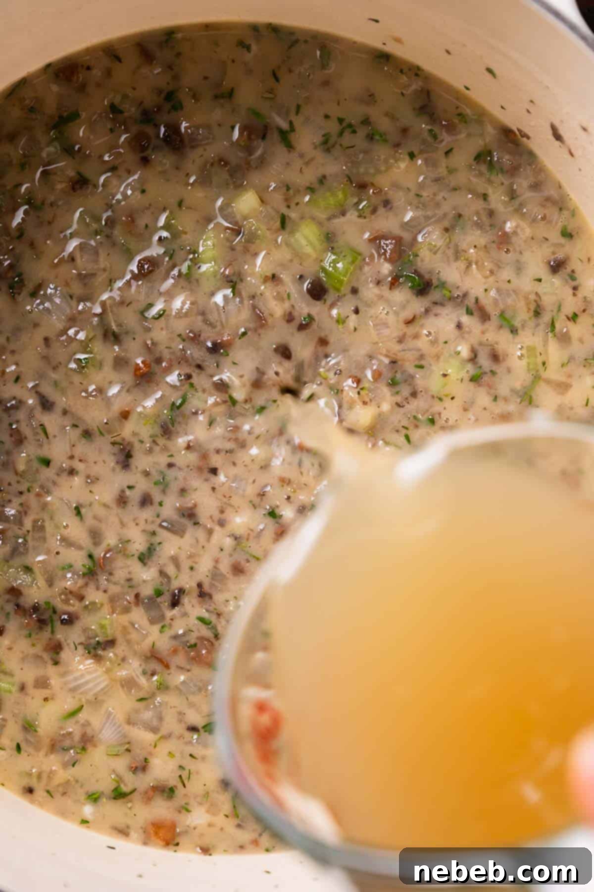 Chicken broth being poured into the sauce.