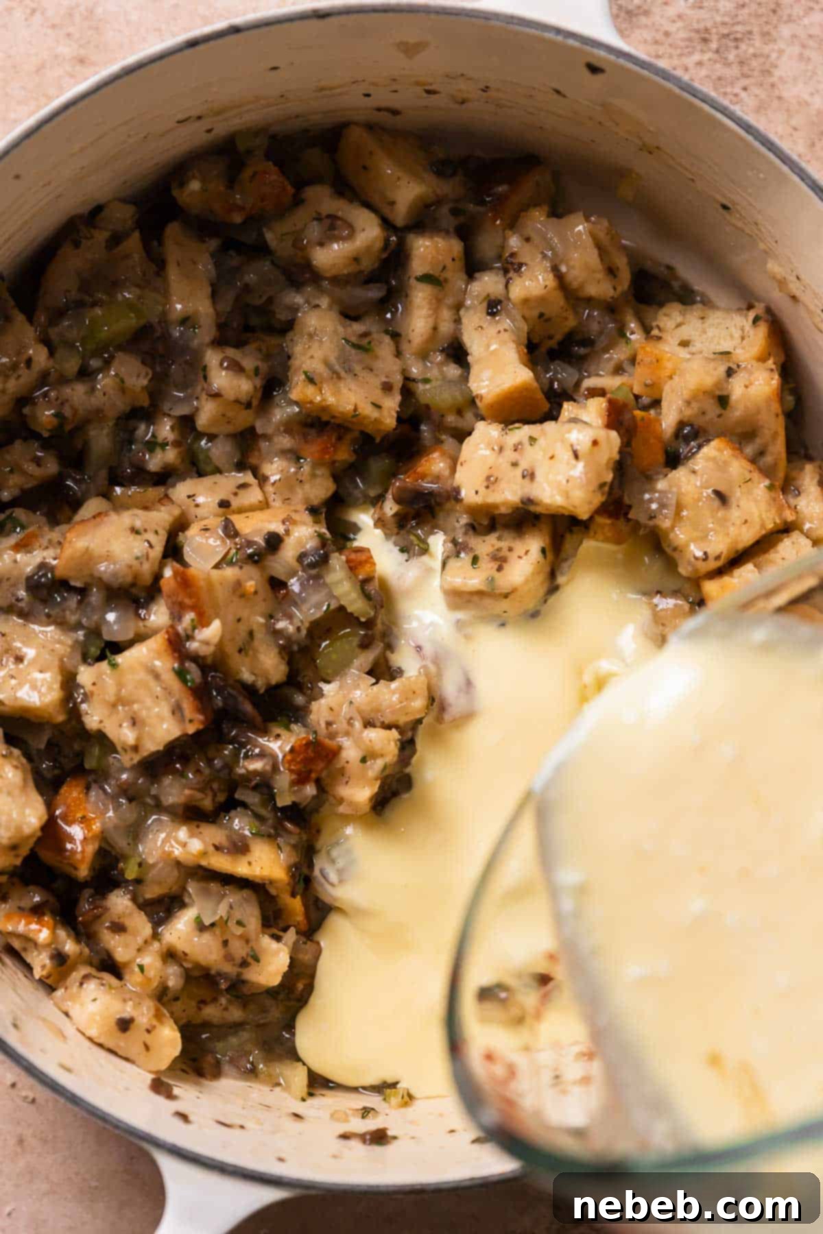 The custard being poured into the bread pudding.