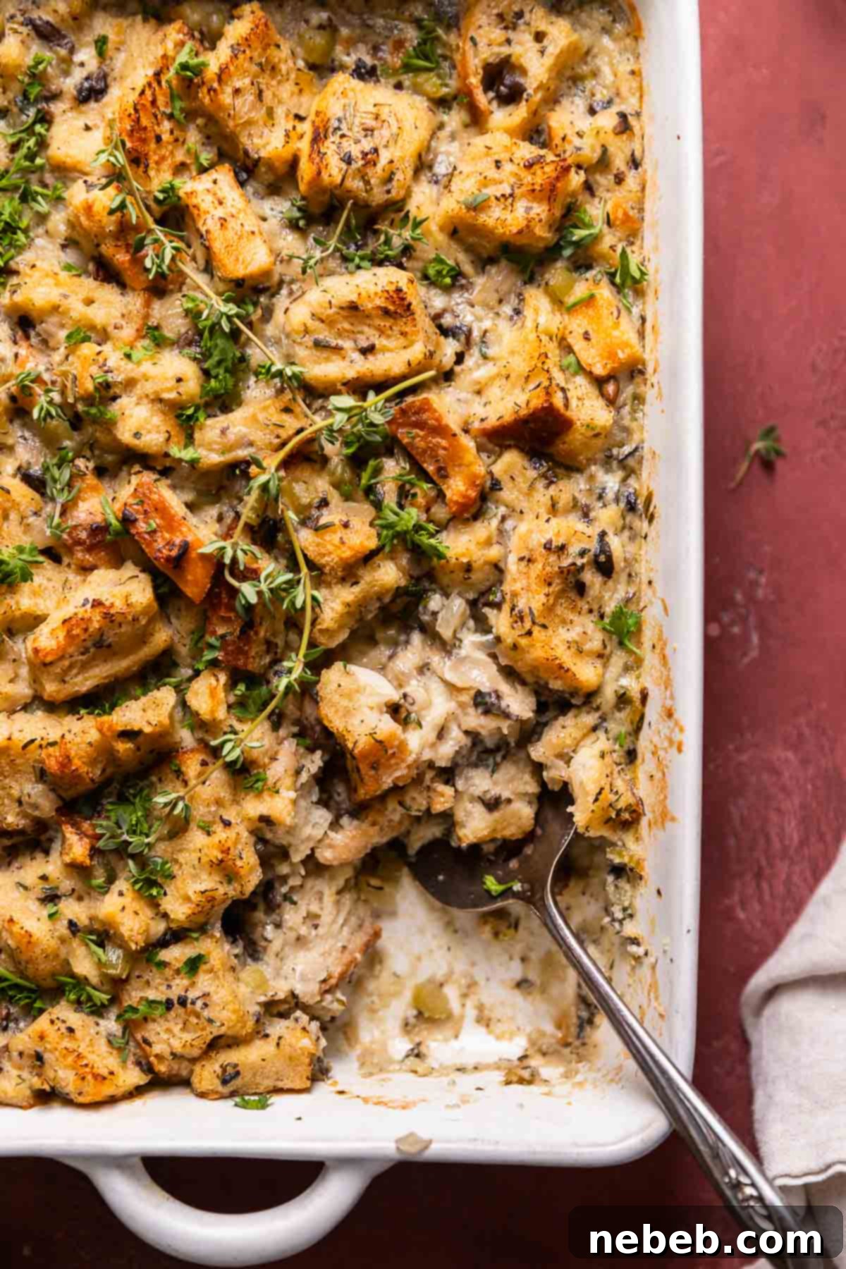 A close up shot of the savory bread casserole with a spoon digging into it.