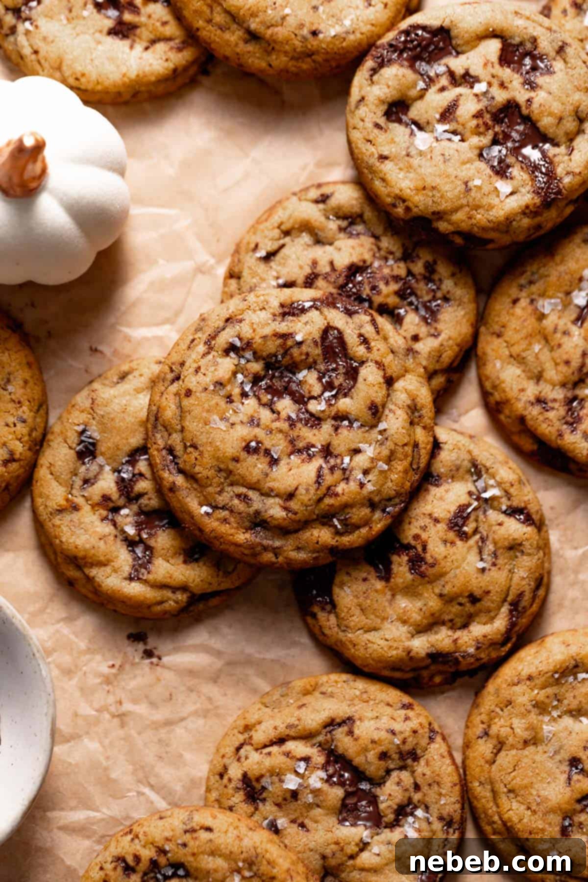 Irresistibly chewy pumpkin chocolate chip cookies with glistening pools of melty chocolate, arranged on parchment paper.