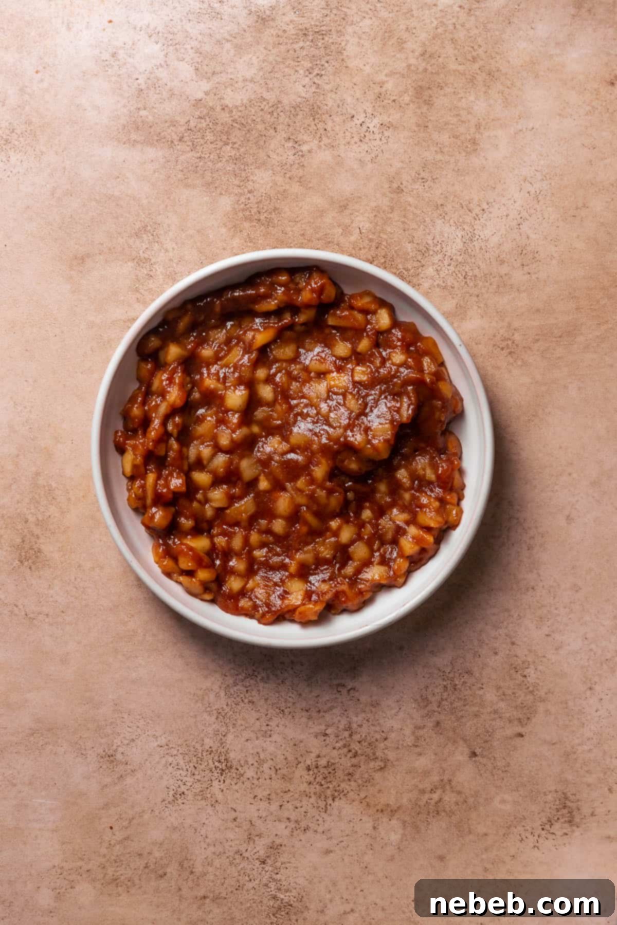 Spiced apple pie filling in a white dish.