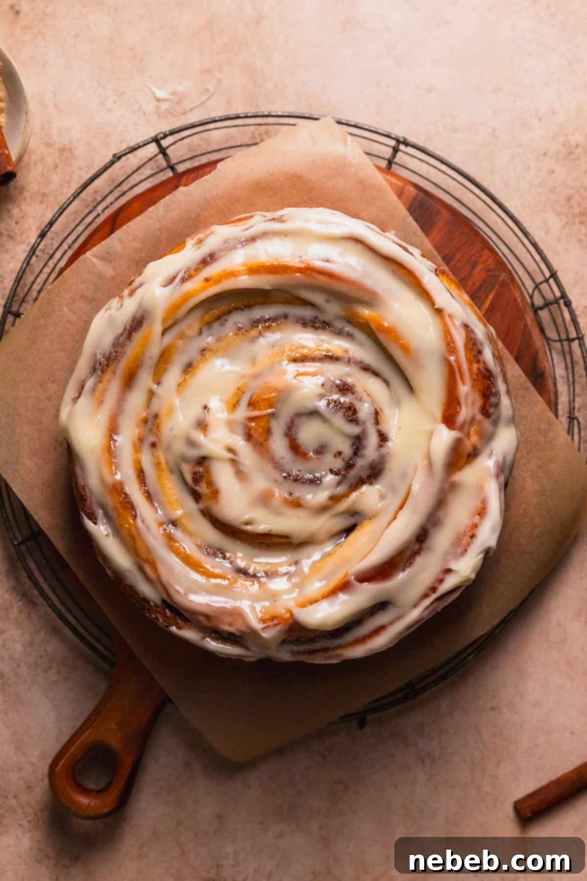 Cinnamon swirl cake on a wooden platter after being frosted.
