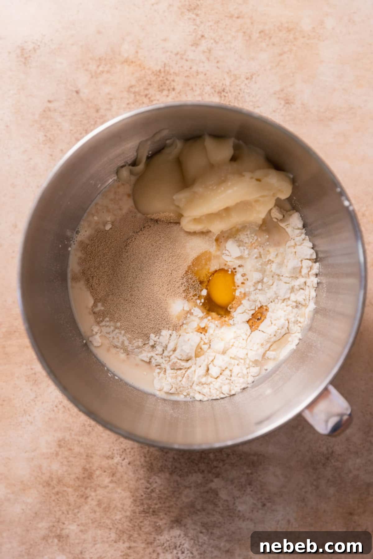 Cinnamon roll ingredients in a mixing bowl before kneading.