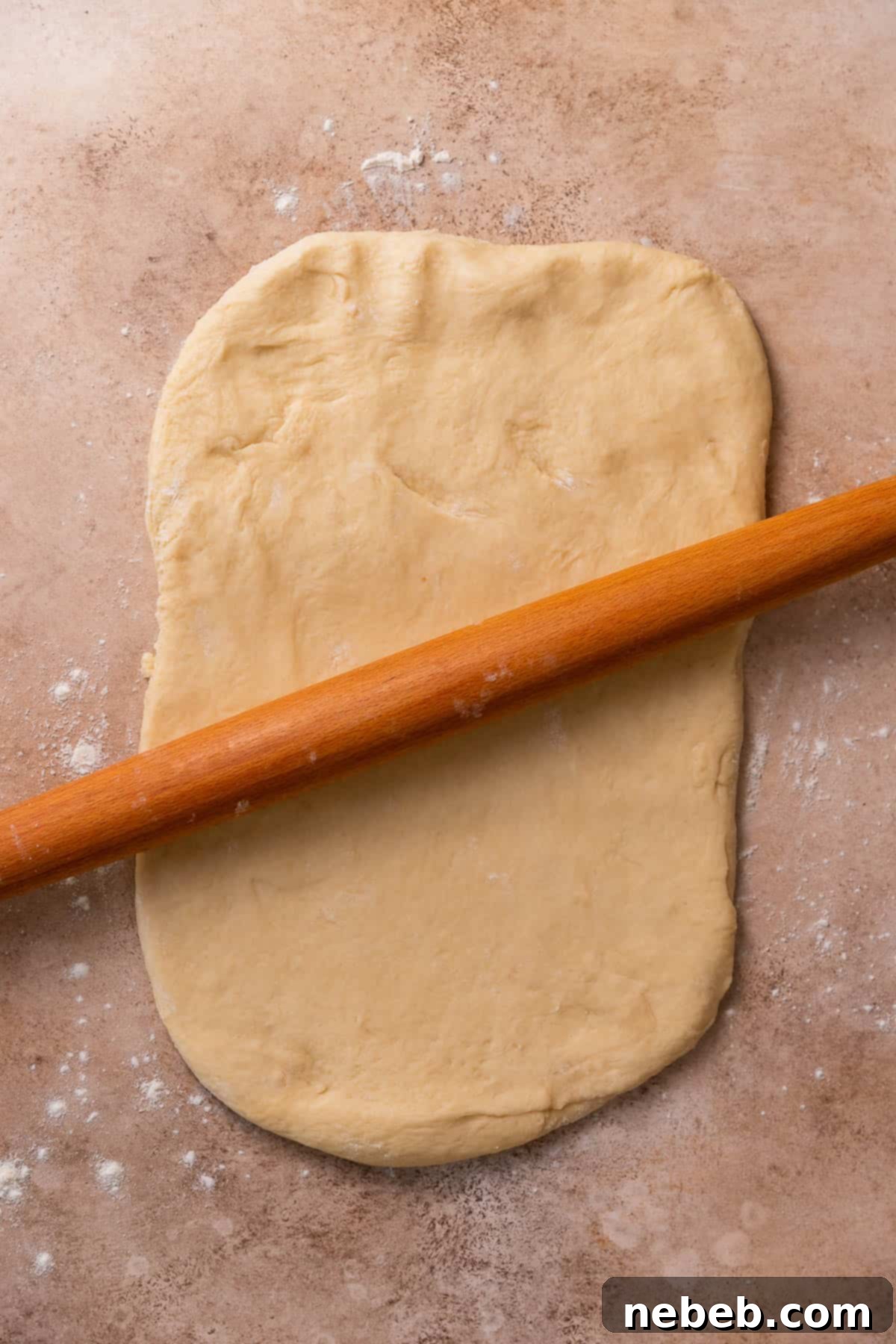 A rolling pin rolling out the dough.