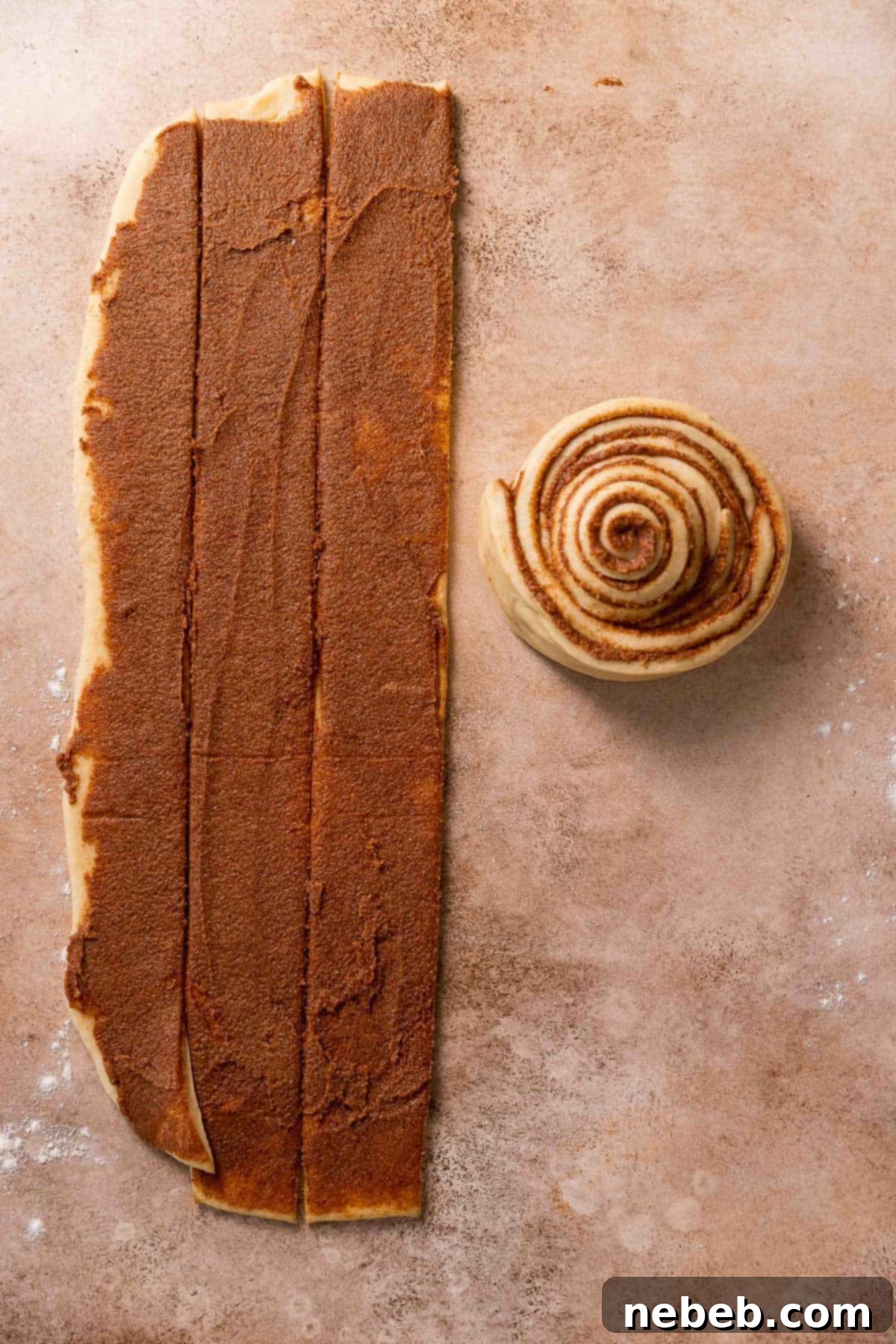 The strips of cinnamon sugar dough being rolled up together into one giant bun.