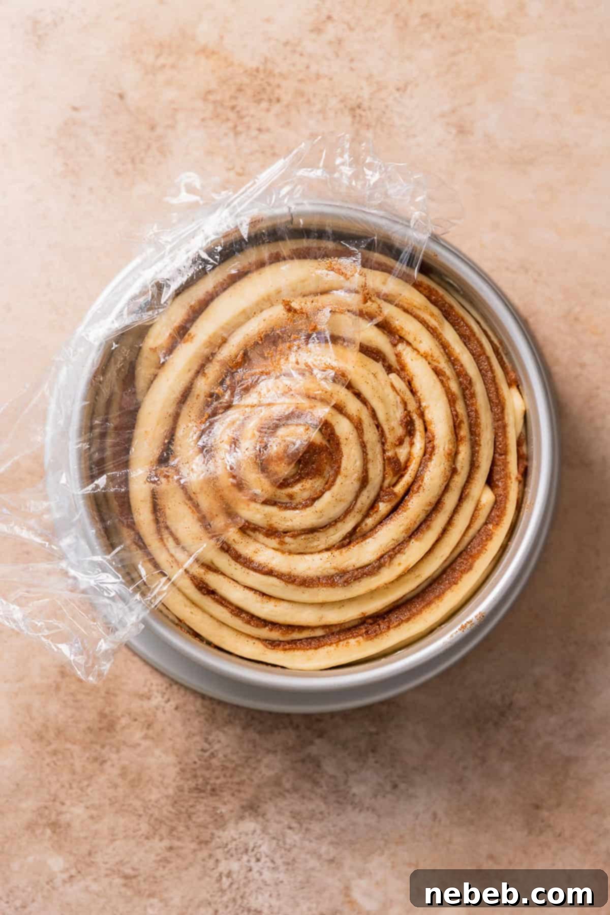The cinnamon bun in a pan doubled in size right before baking.