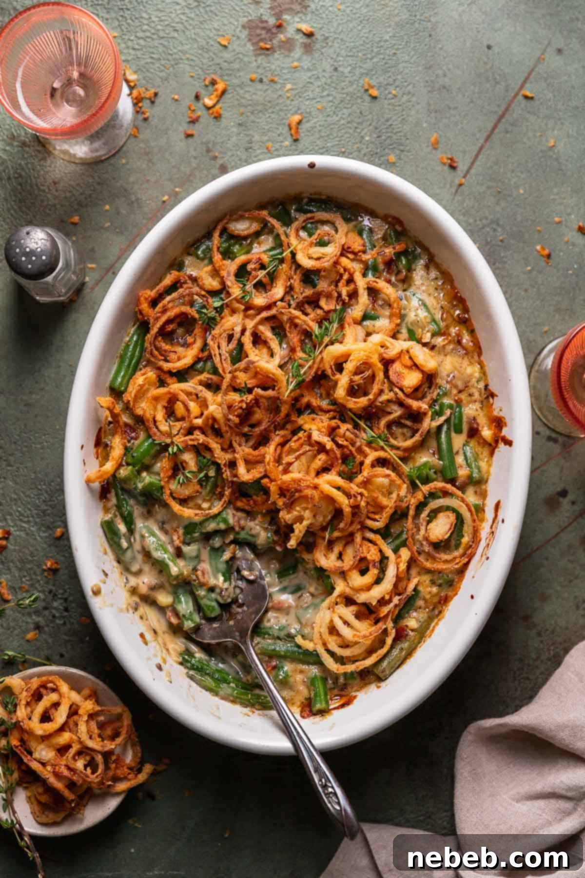 Delicious homemade cheesy green bean casserole, topped with golden crispy fried shallots, ready for Thanksgiving.