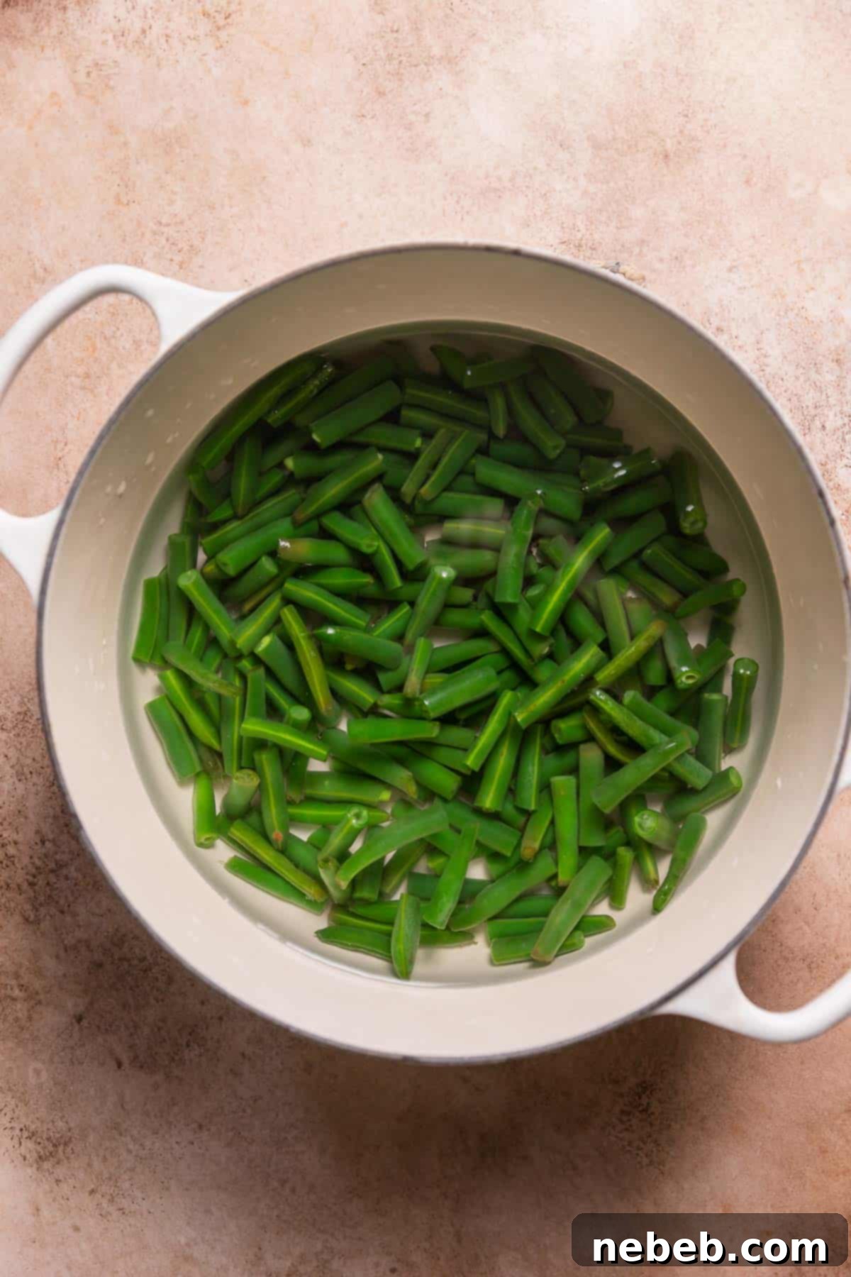 Fresh green beans boiling in a pot of water, preparing for blanching.