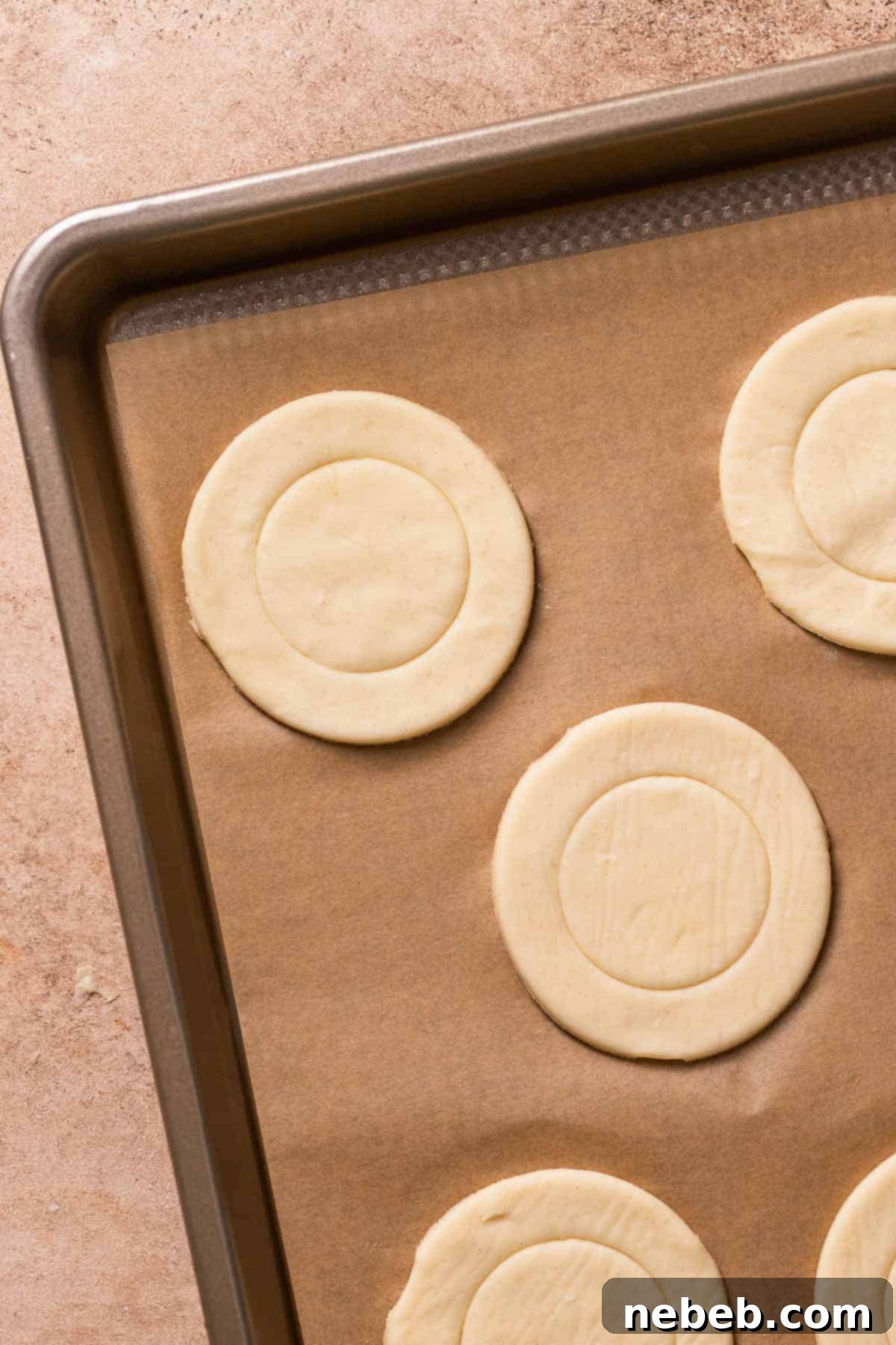 Puff pastry circles on a baking sheet.