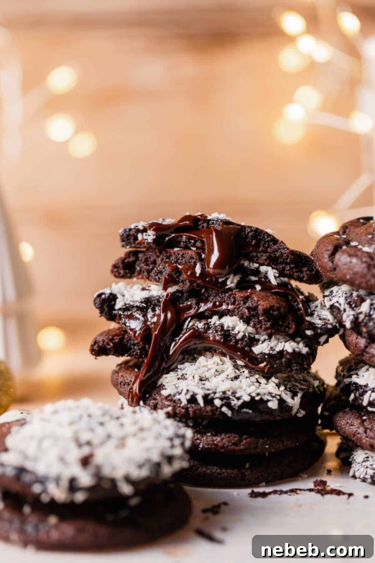A stack of chocolate cookies with fudge filling oozing out.