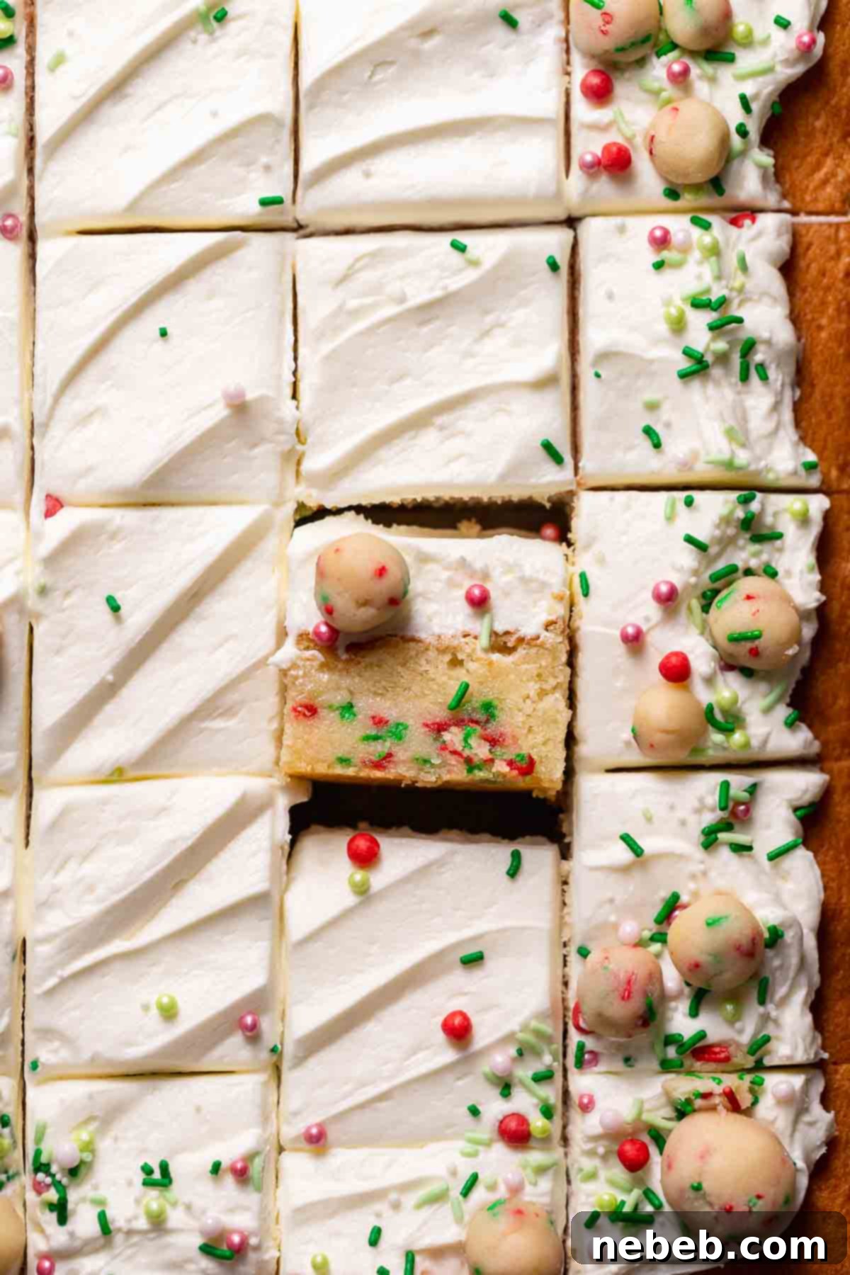 A perfectly baked slice of Sugar Cookie Cake, showcasing the moist vanilla cake with visible layers of sugar cookie dough and a generous dollop of fluffy vanilla frosting on top.